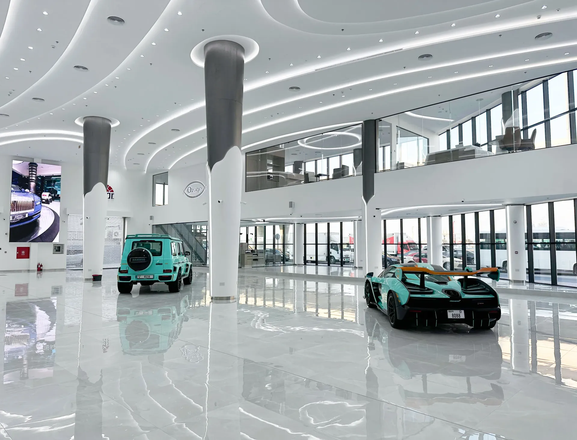 Luxury car showroom fit-out in Dubai featuring double-height architectural ceiling and premium vehicle display by Concept Art Decor