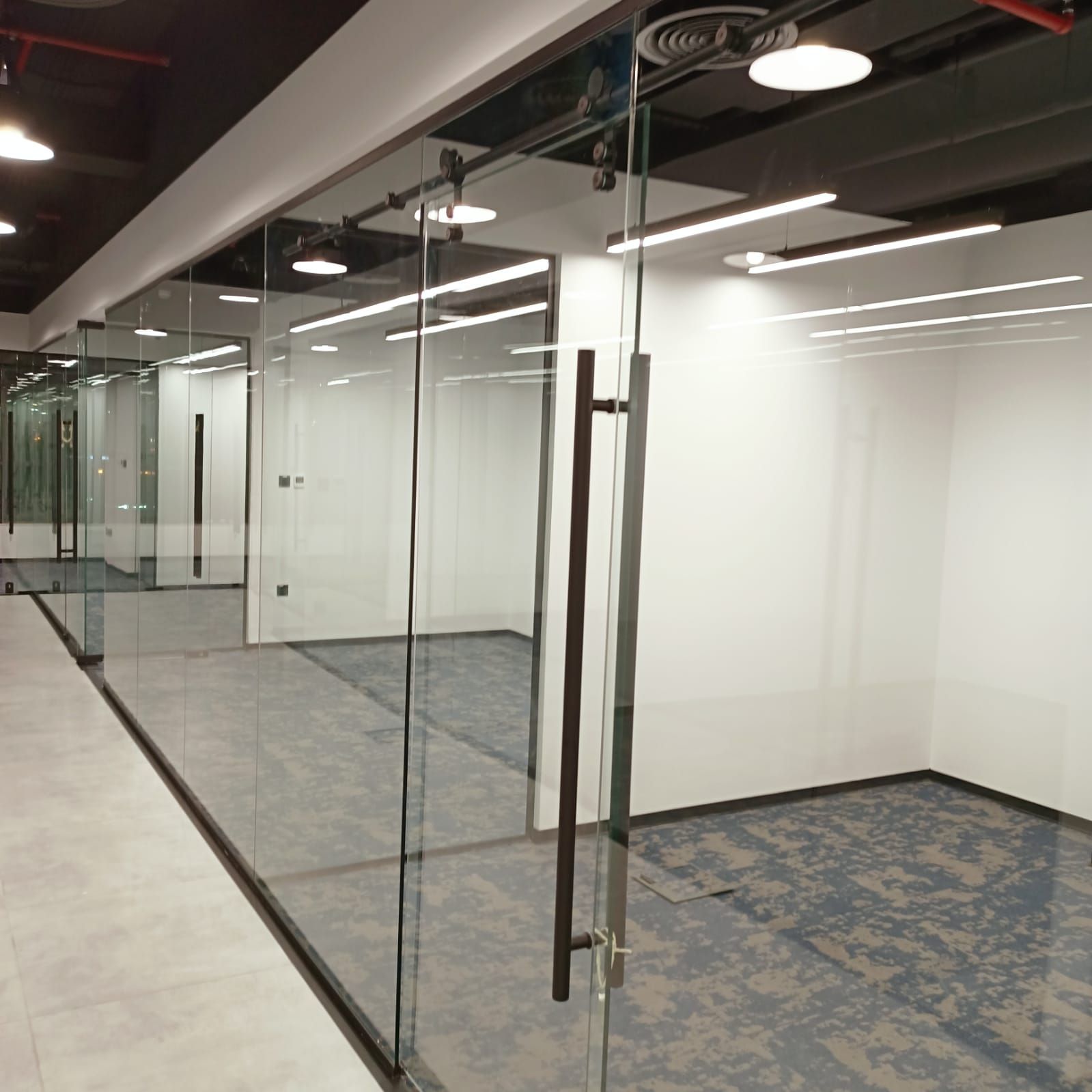 Corporate office fit-out in Dubai with glass partitions, modern lighting and ergonomic workstations by Concept Art Decor.