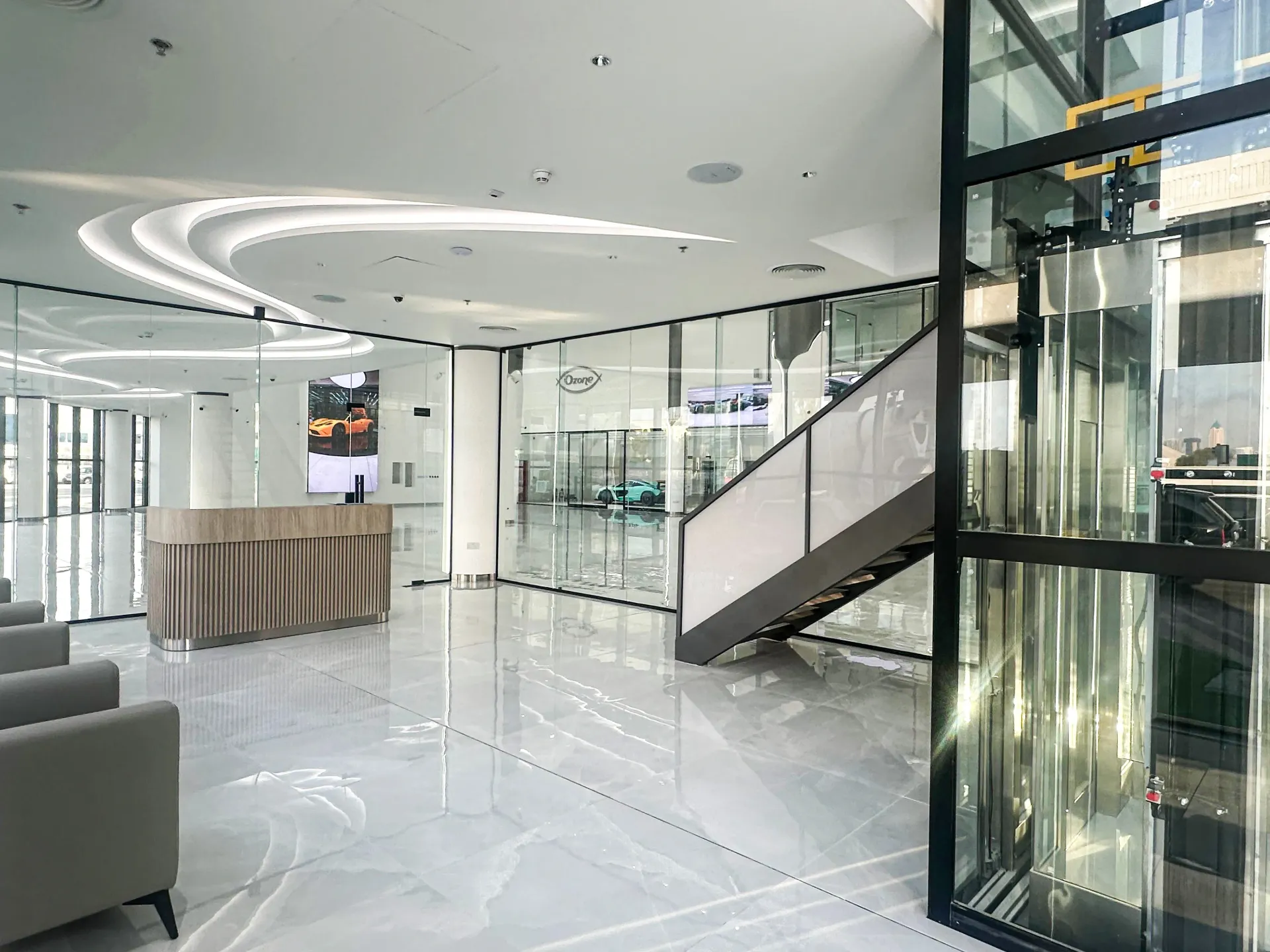 Glass elevator and mezzanine steel structure installed inside a luxury showroom fit-out in Dubai by Concept Art Decor