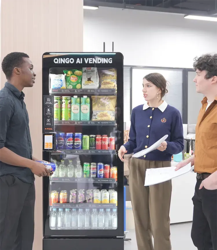 Woman selecting a drink from a coffee machine in an office setting.