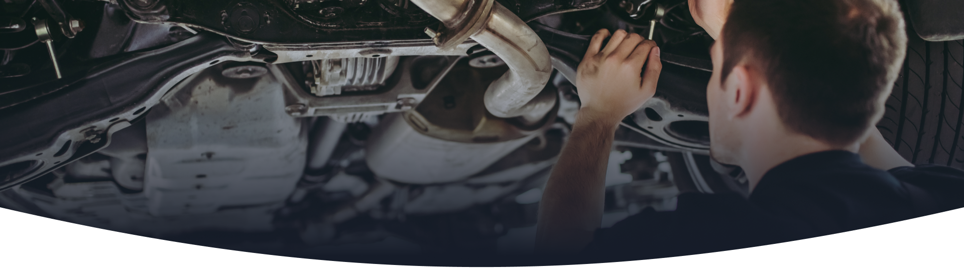 A man is working on the underside of a car.