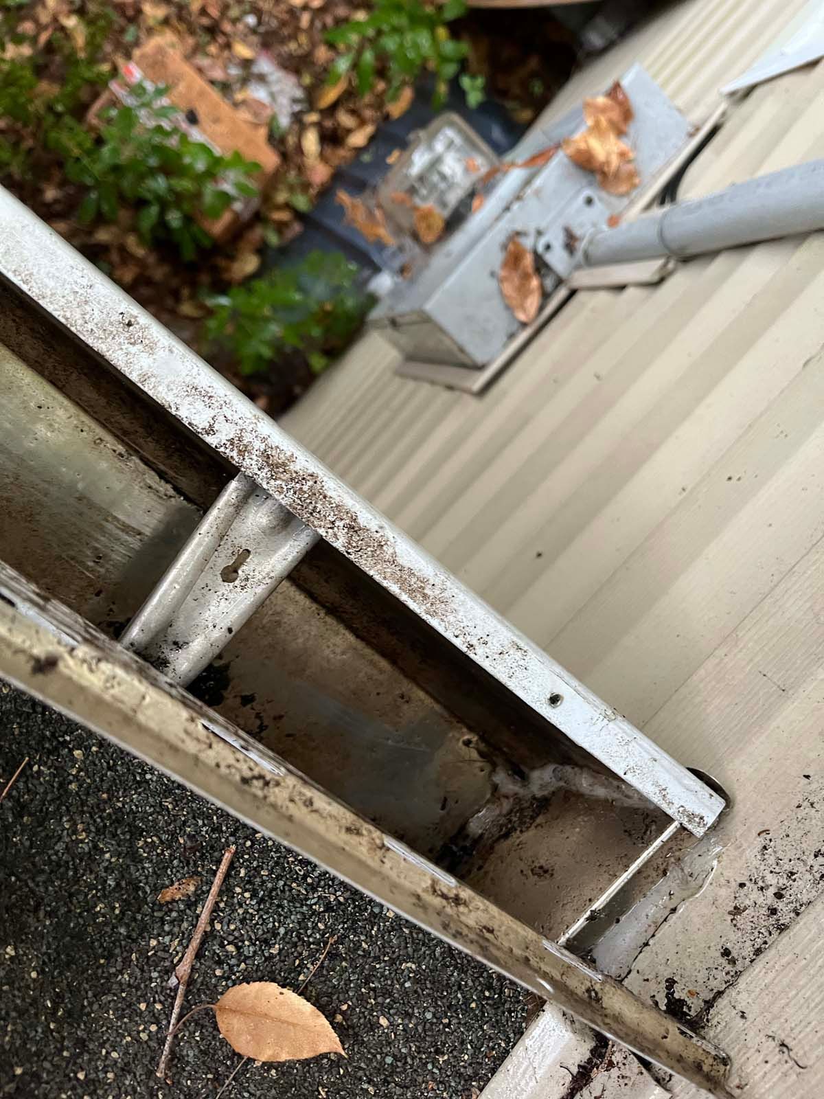 A close up of a gutter on the side of a house.