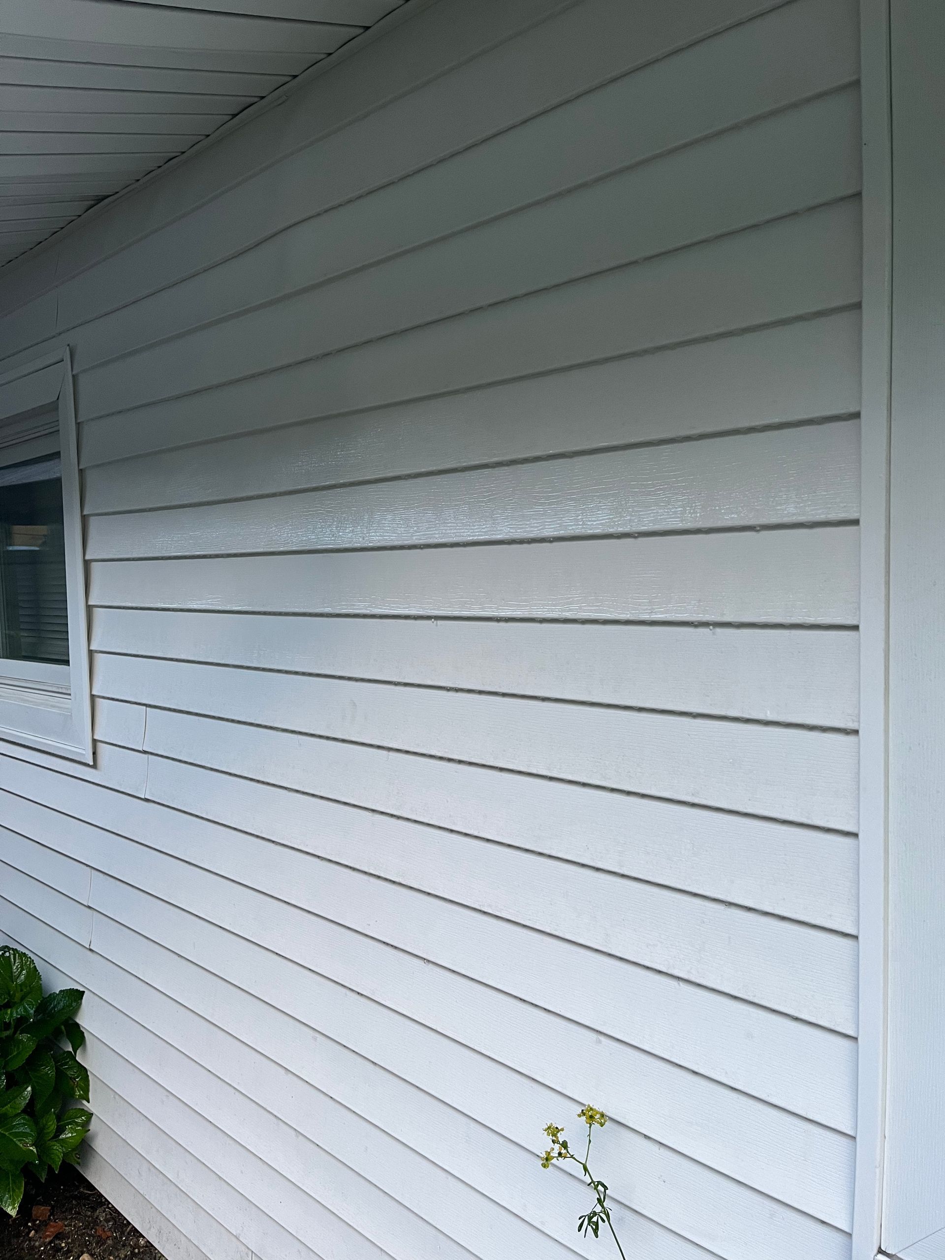 A white house with a window on the side of it