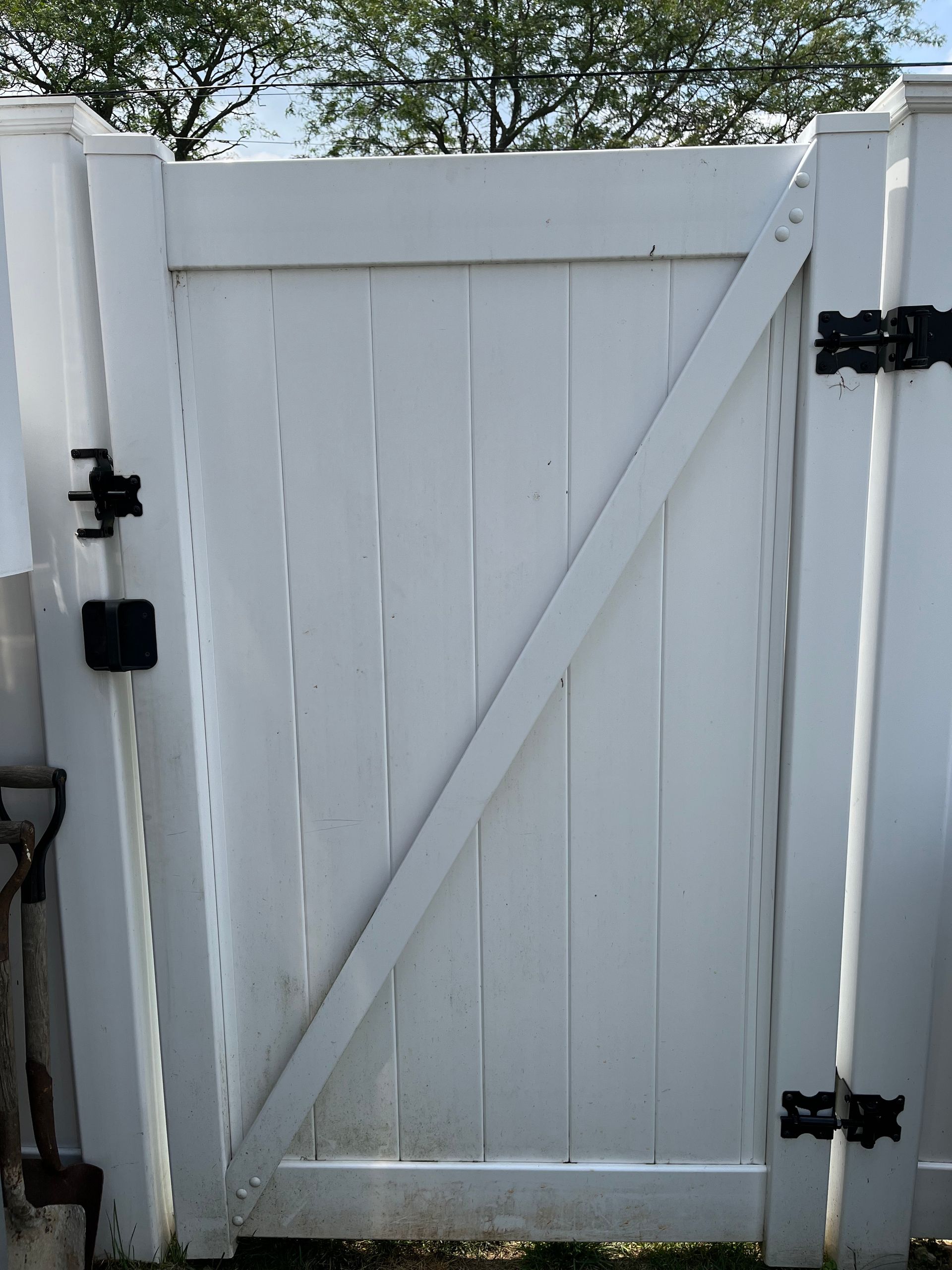 A white fence with a gate that is open