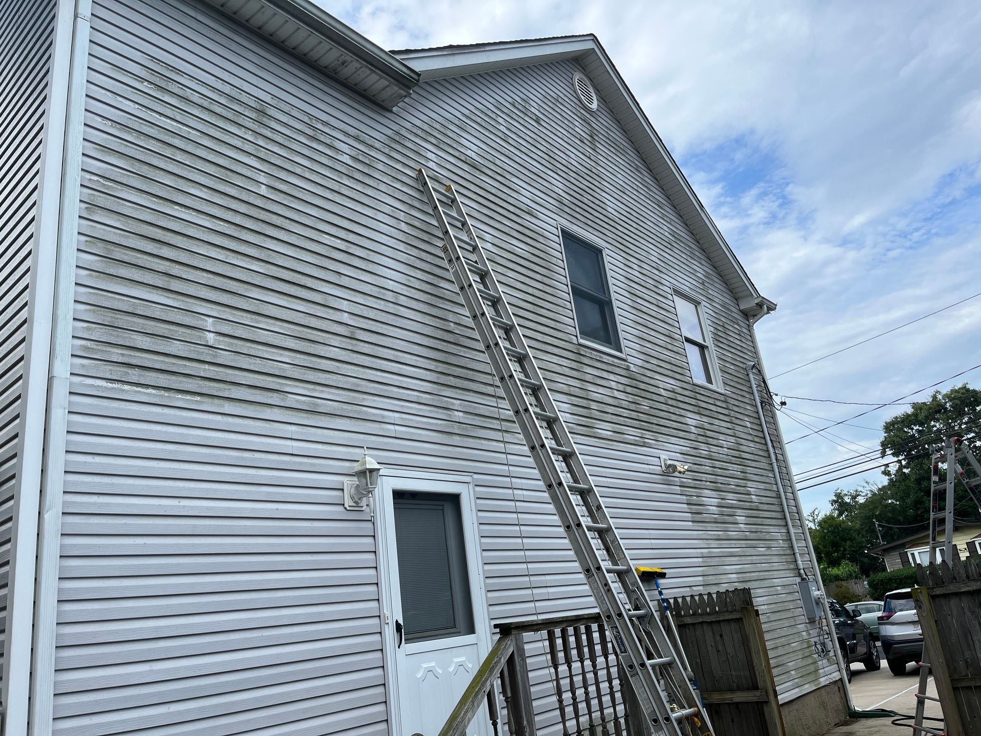A white house with a ladder attached to the side of it.