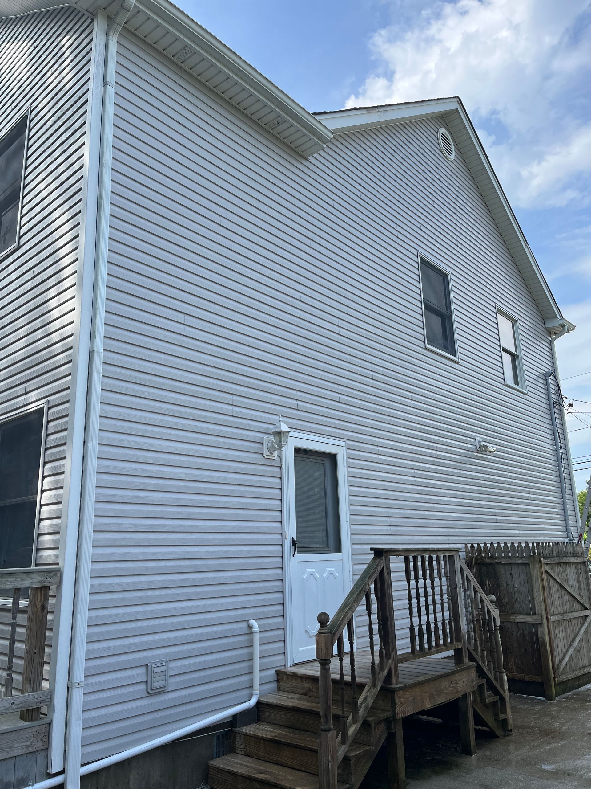 A white house with a white door and stairs.