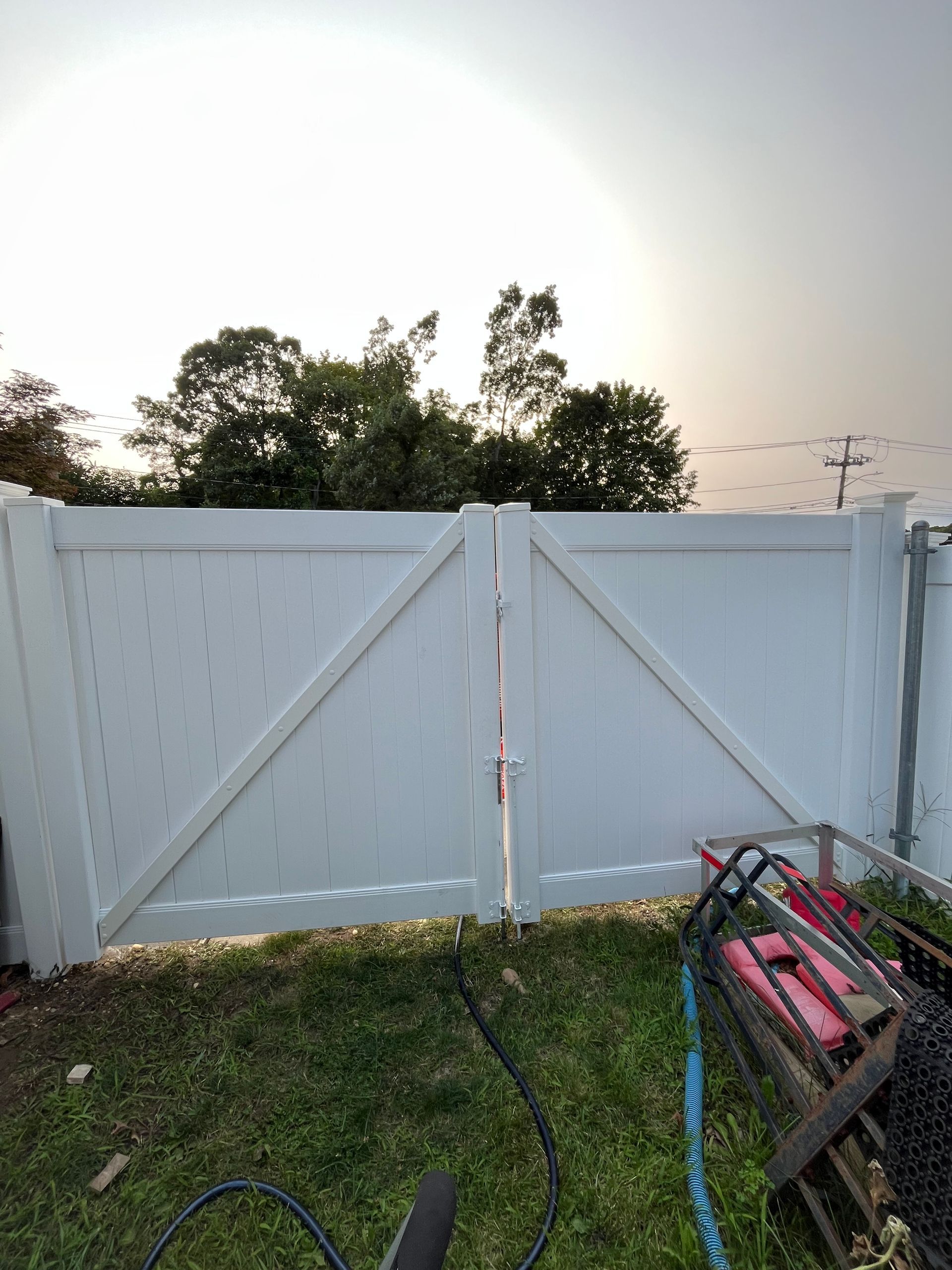 A white fence is sitting in the middle of a lush green field.