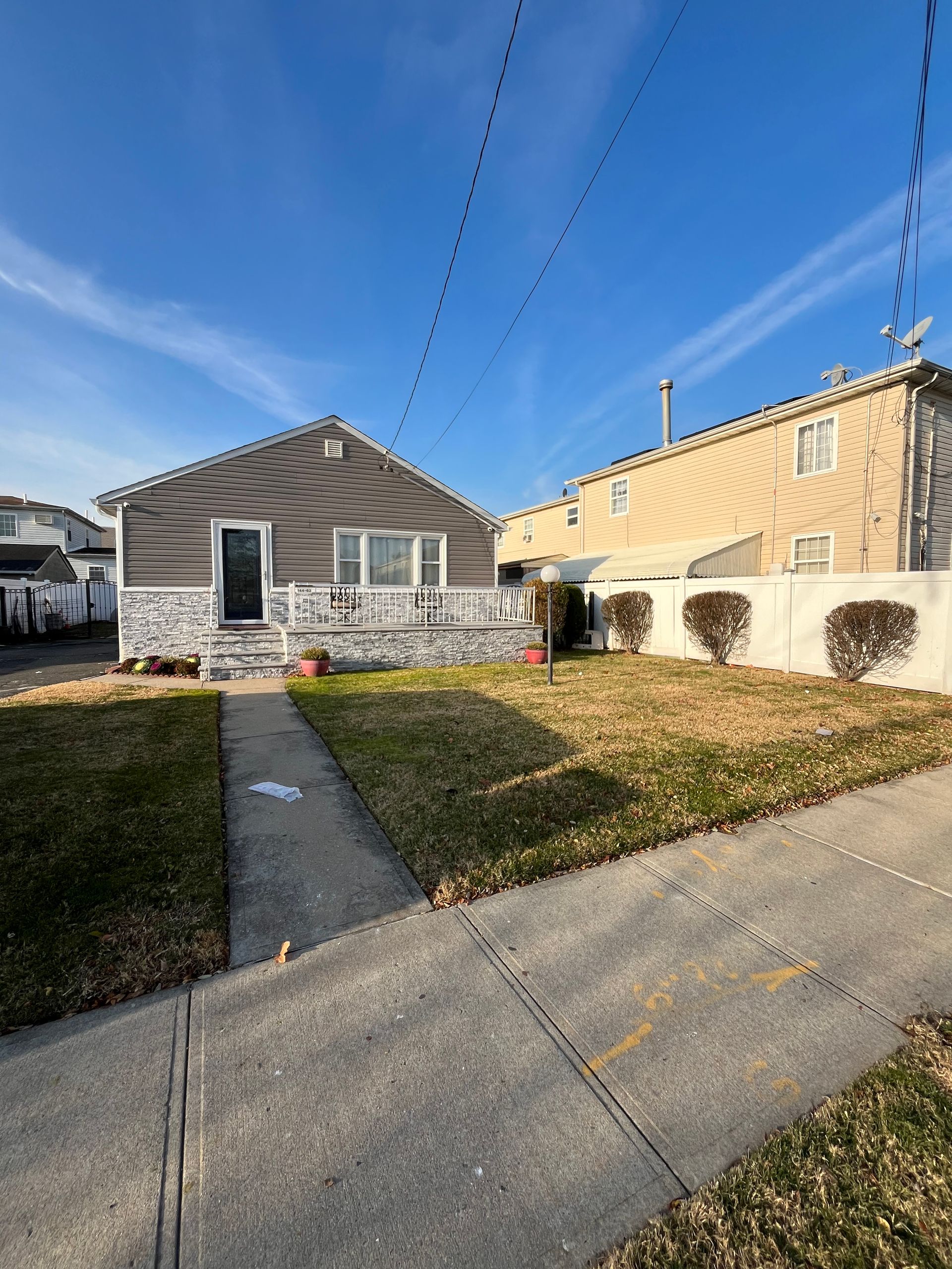 A house with a lot of grass and a sidewalk in front of it.