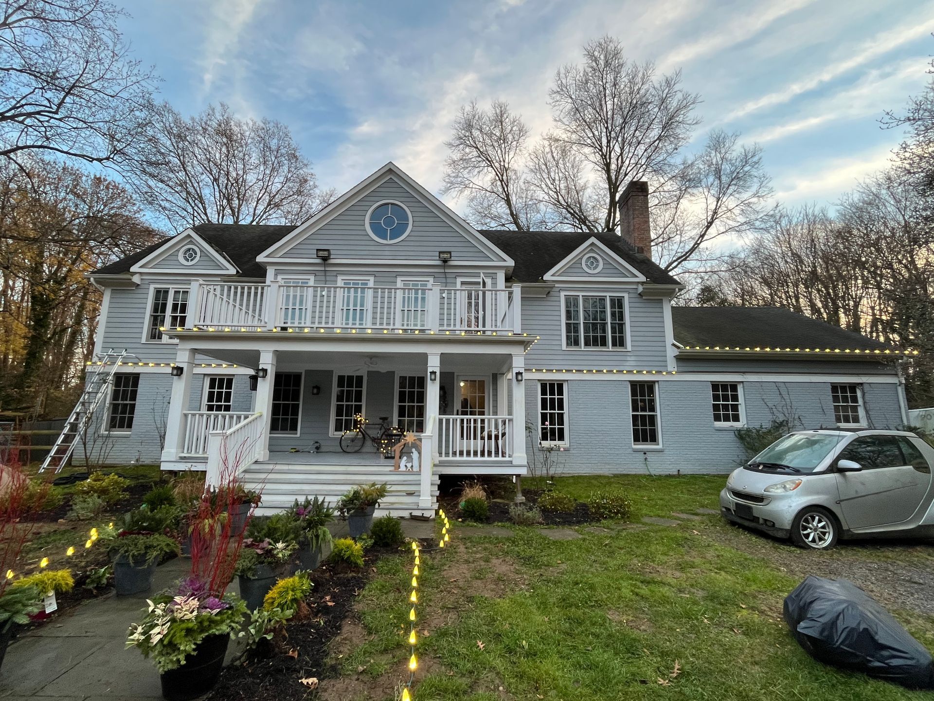 A large white house with a car parked in front of it.