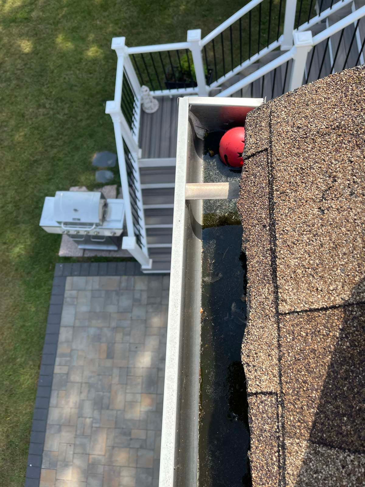 An aerial view of a gutter on a roof next to a deck.