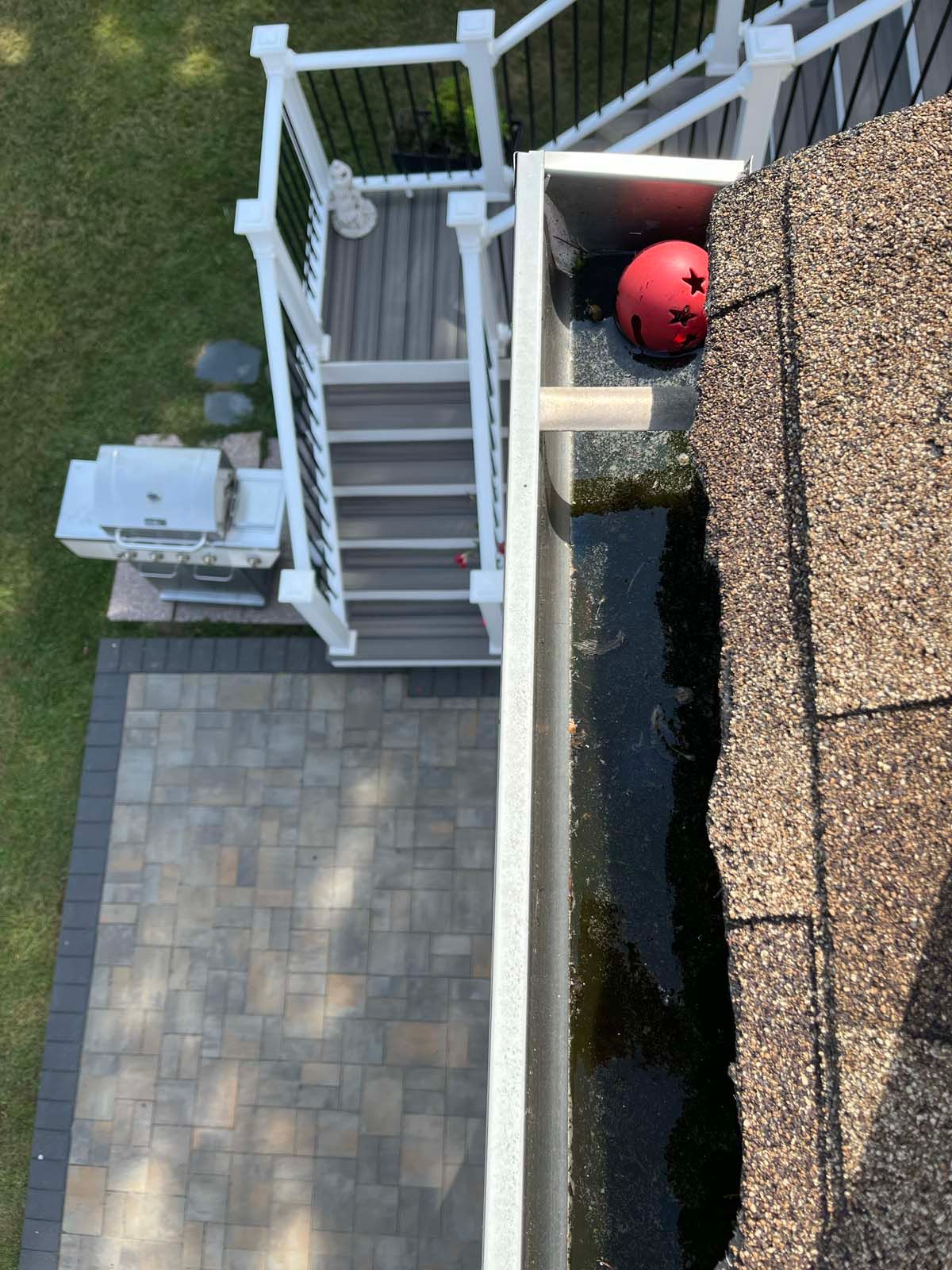 An aerial view of a gutter on a roof next to a deck.