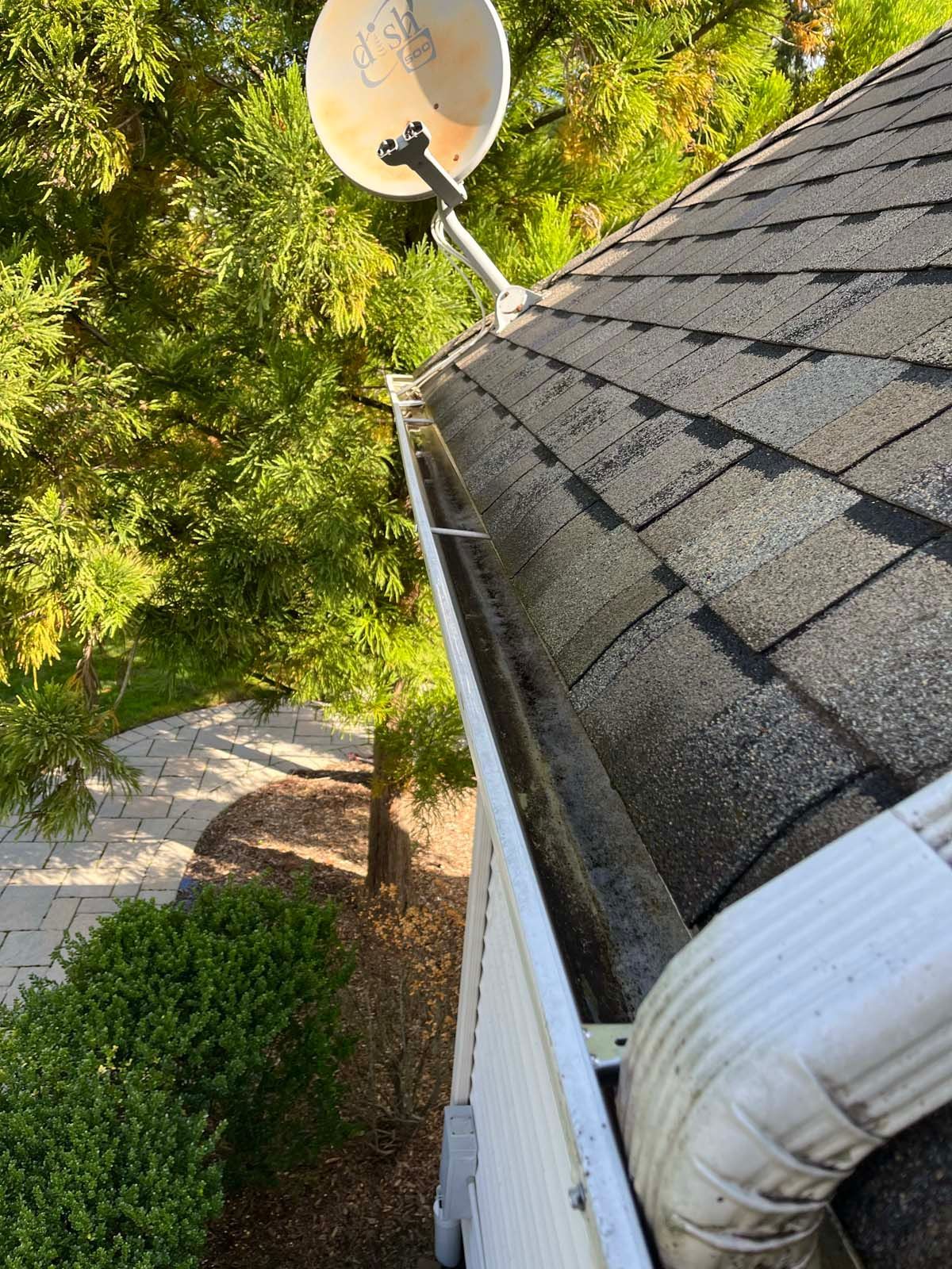 A gutter with a satellite dish on top of it.