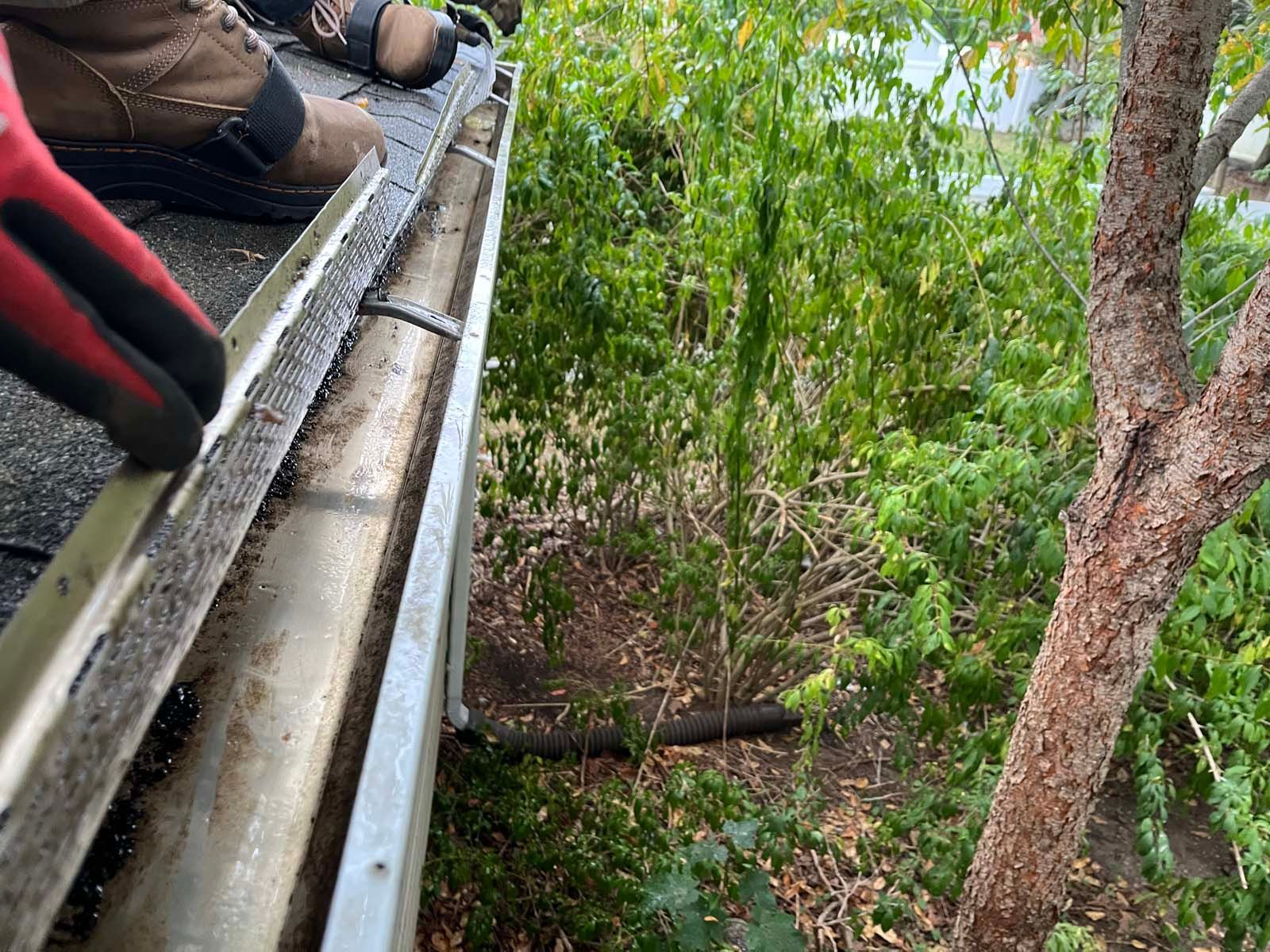 A person is cutting a gutter with a saw.