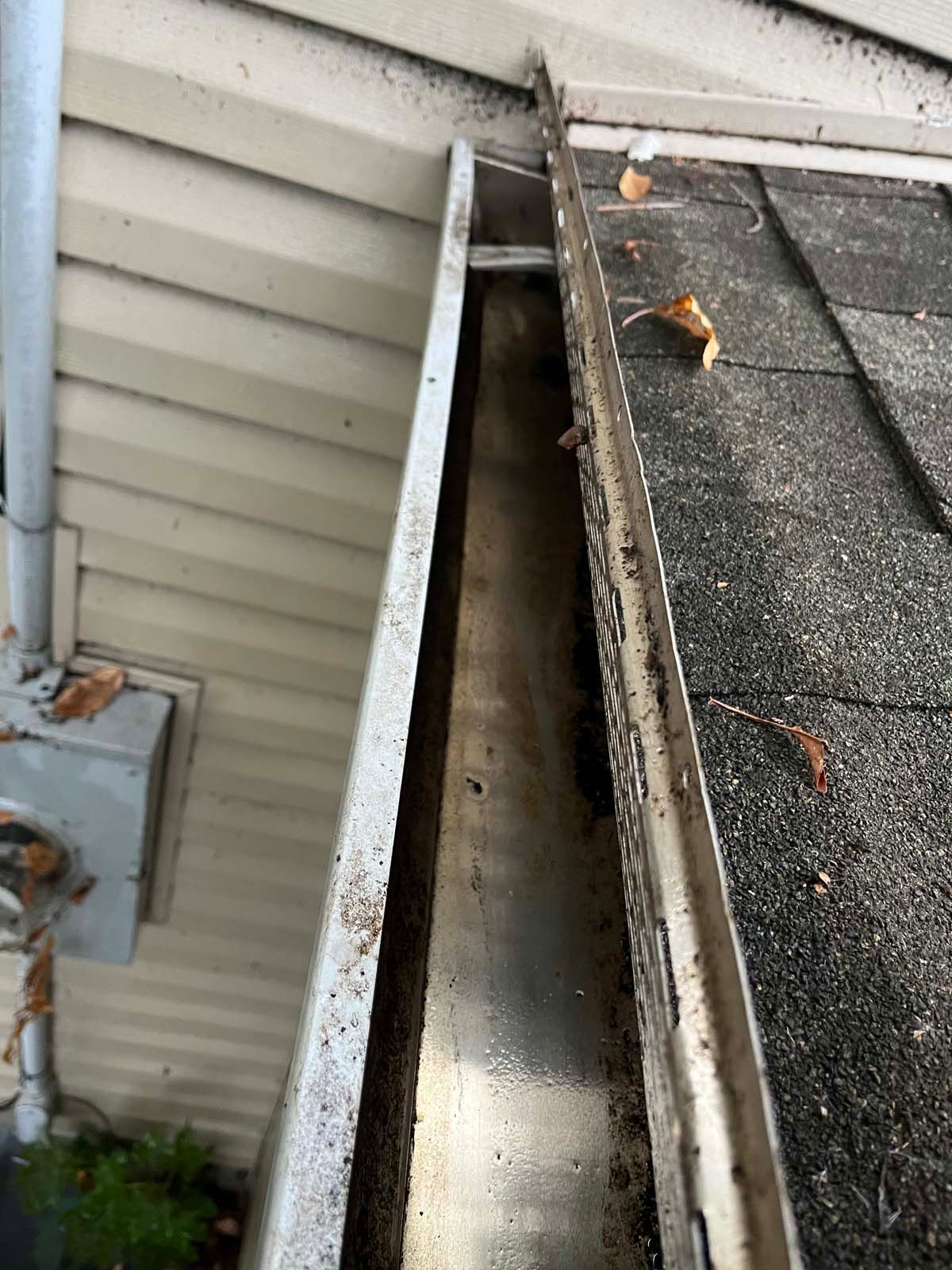 A close up of a gutter on the side of a house.