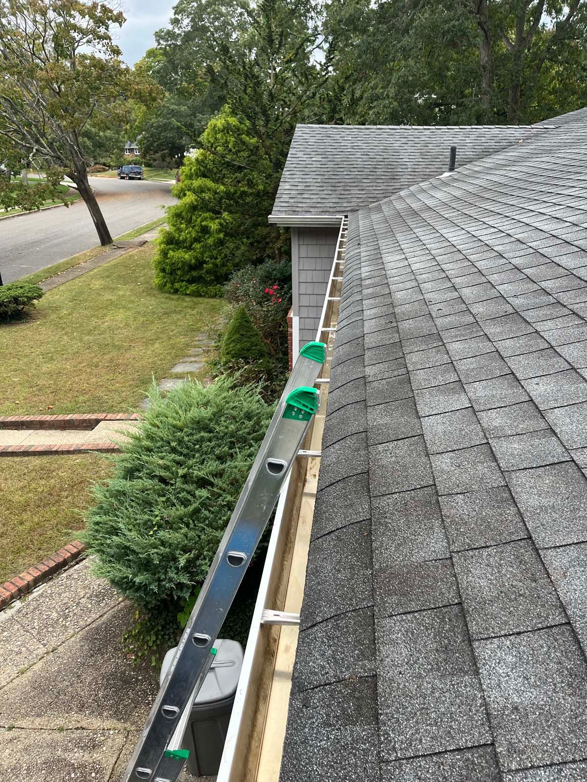A ladder is attached to a gutter on the side of a house.