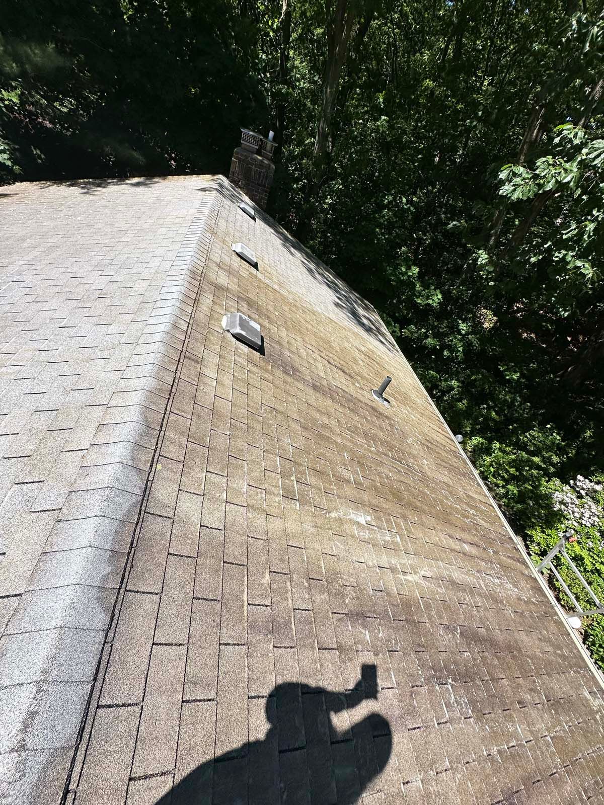A roof with a shadow of a person on it.