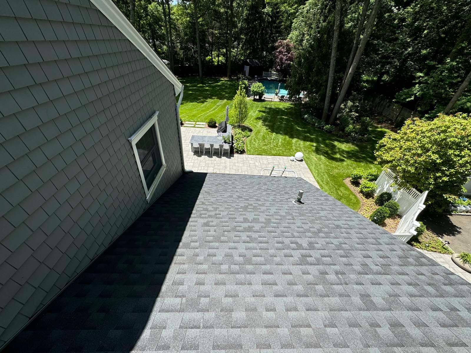 A rooftop view of a house with a pool in the backyard.