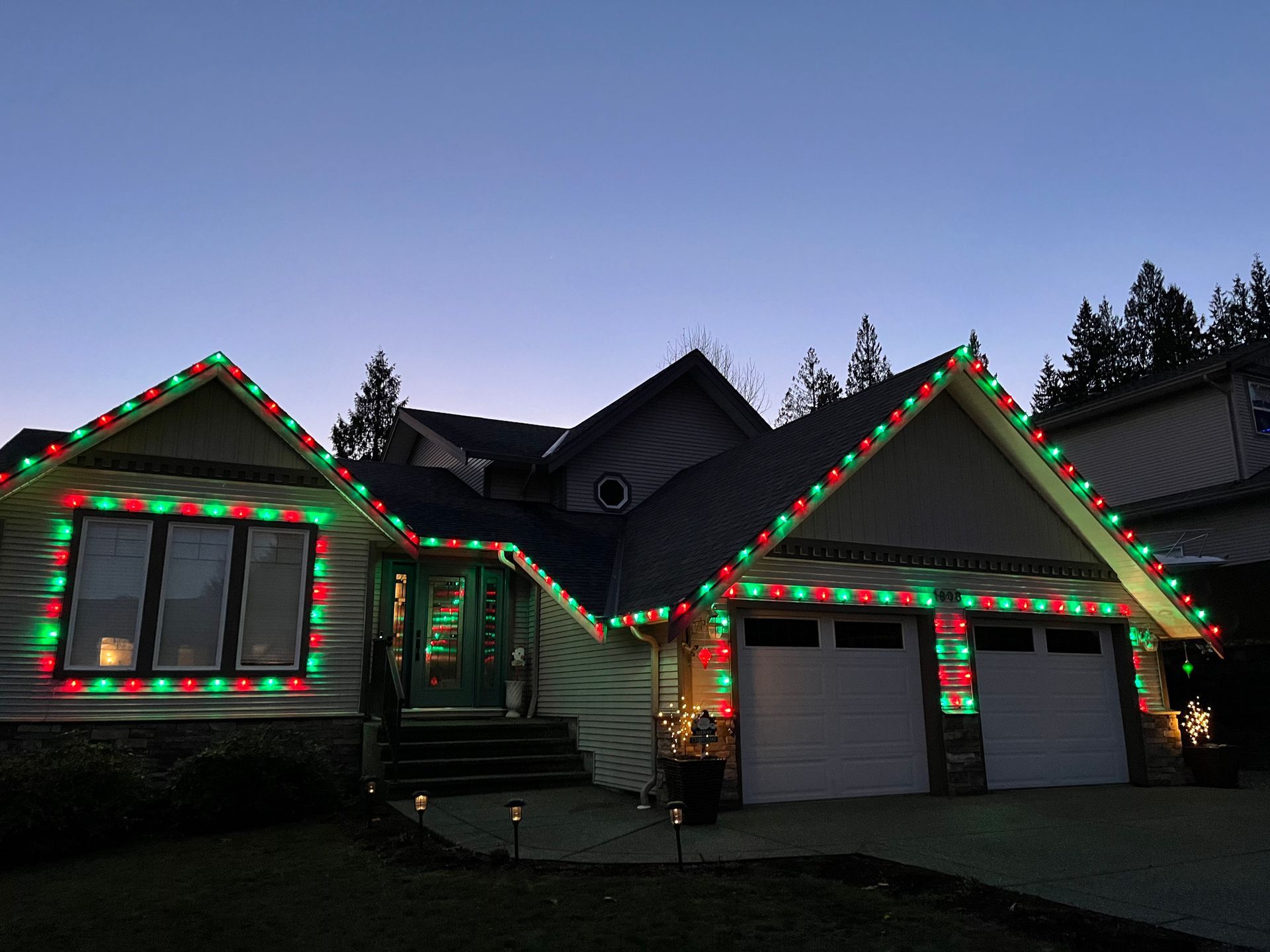 A house is decorated with red and green christmas lights.