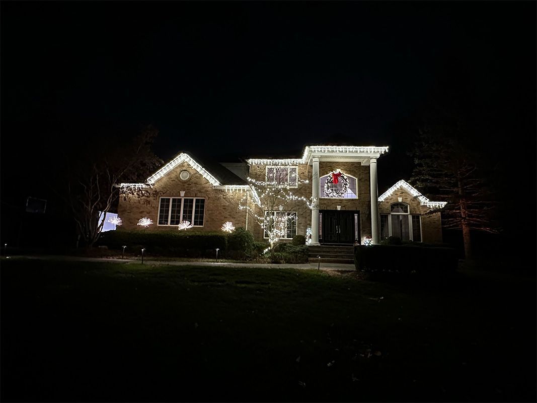 House at night decorated with white Christmas lights.