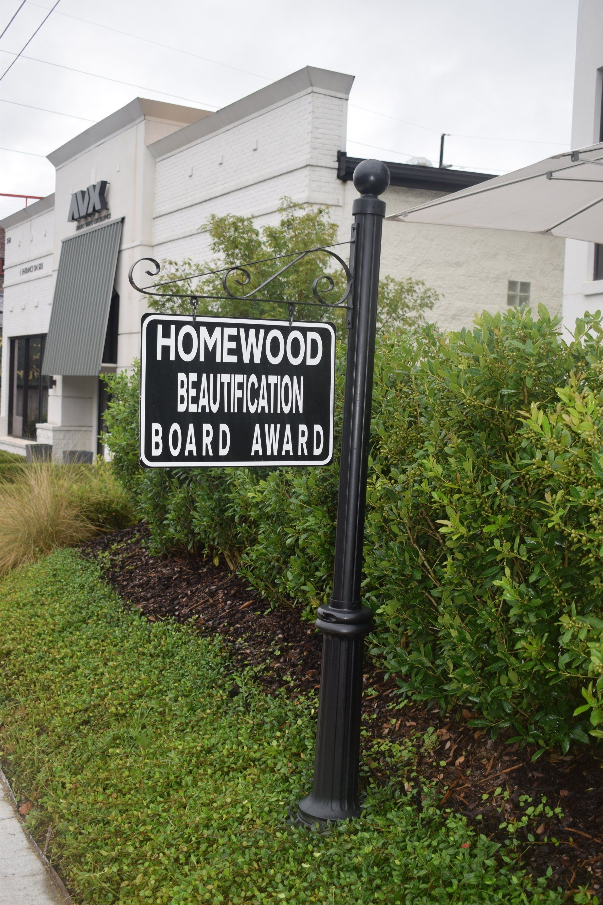 A sign on a pole that says homewood beautification board award