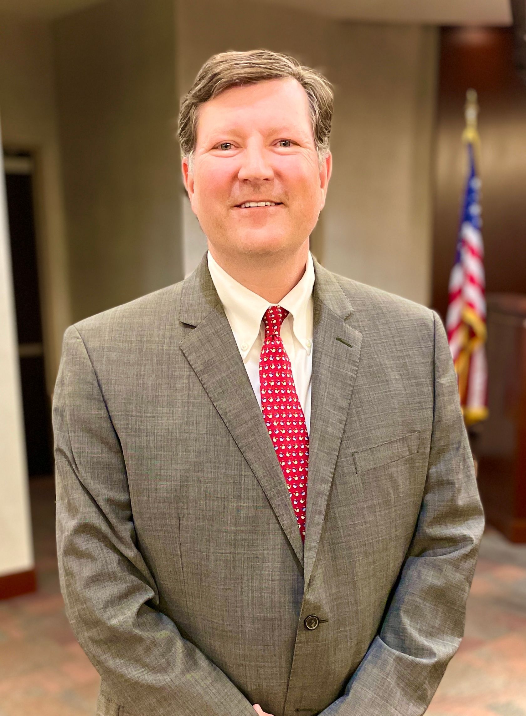 A man in a suit and tie is smiling for the camera