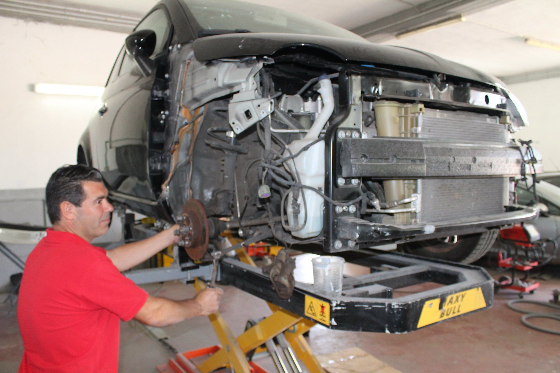 il carrozziere che cambia pezzi di una macchina incidentata