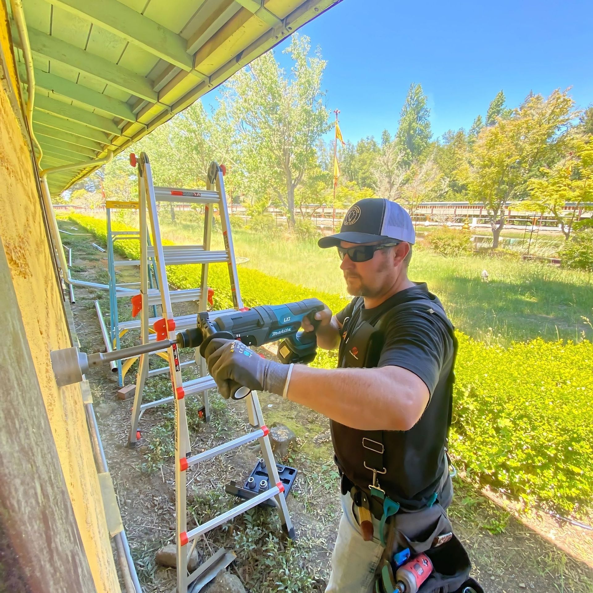 The Electric Pro - A man is using a hammer to drill a hole in a wall.