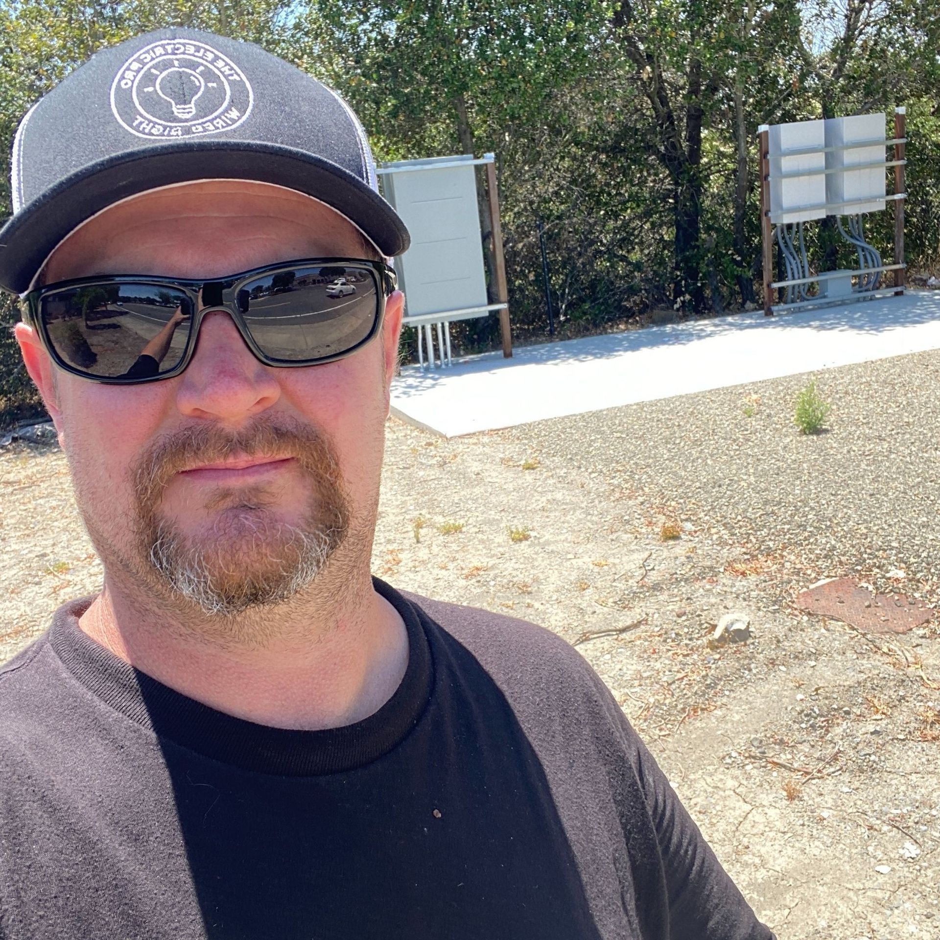 The Electric Pro - A man wearing sunglasses and a hat is standing in a field.