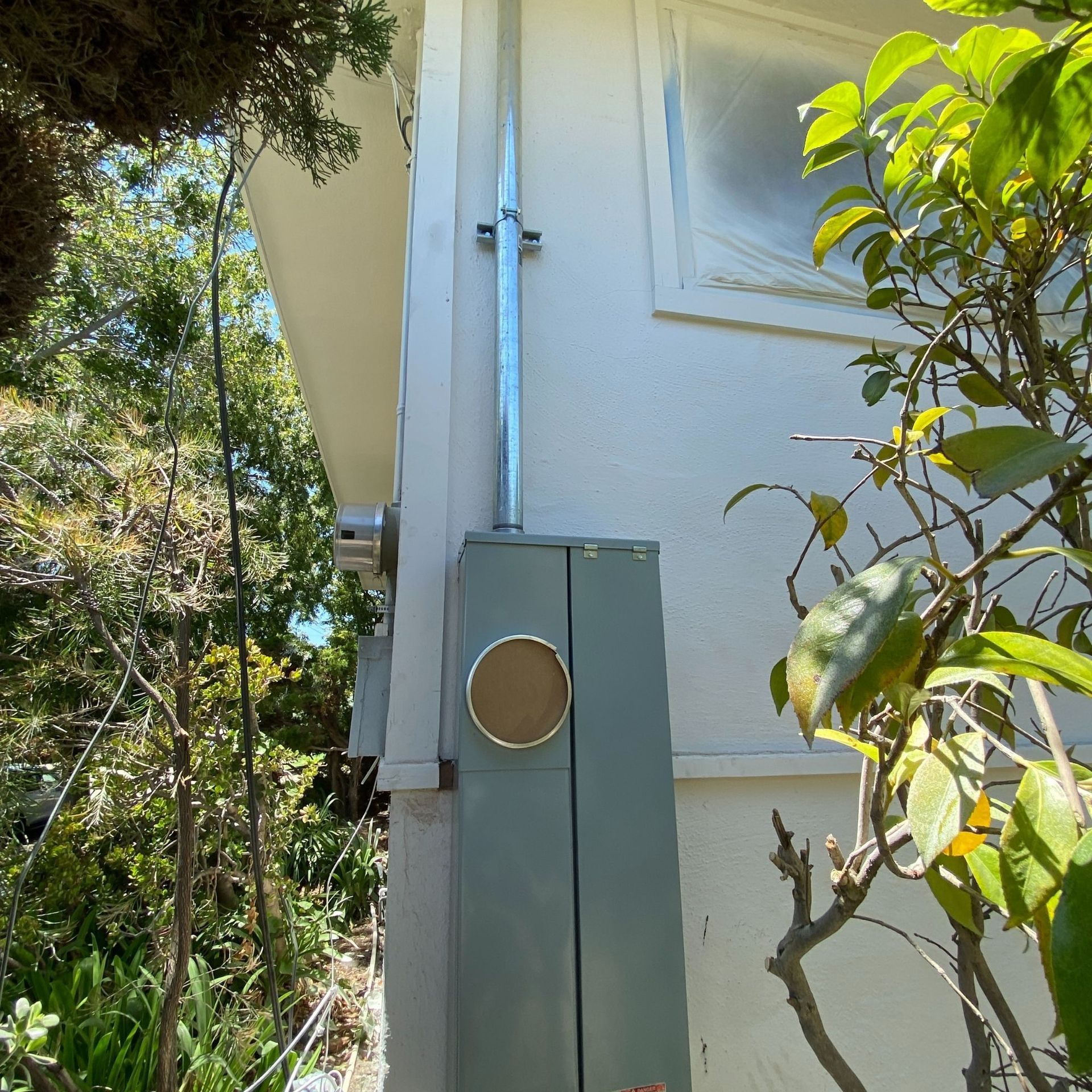 The Electric Pro - A gray box on the side of a white house