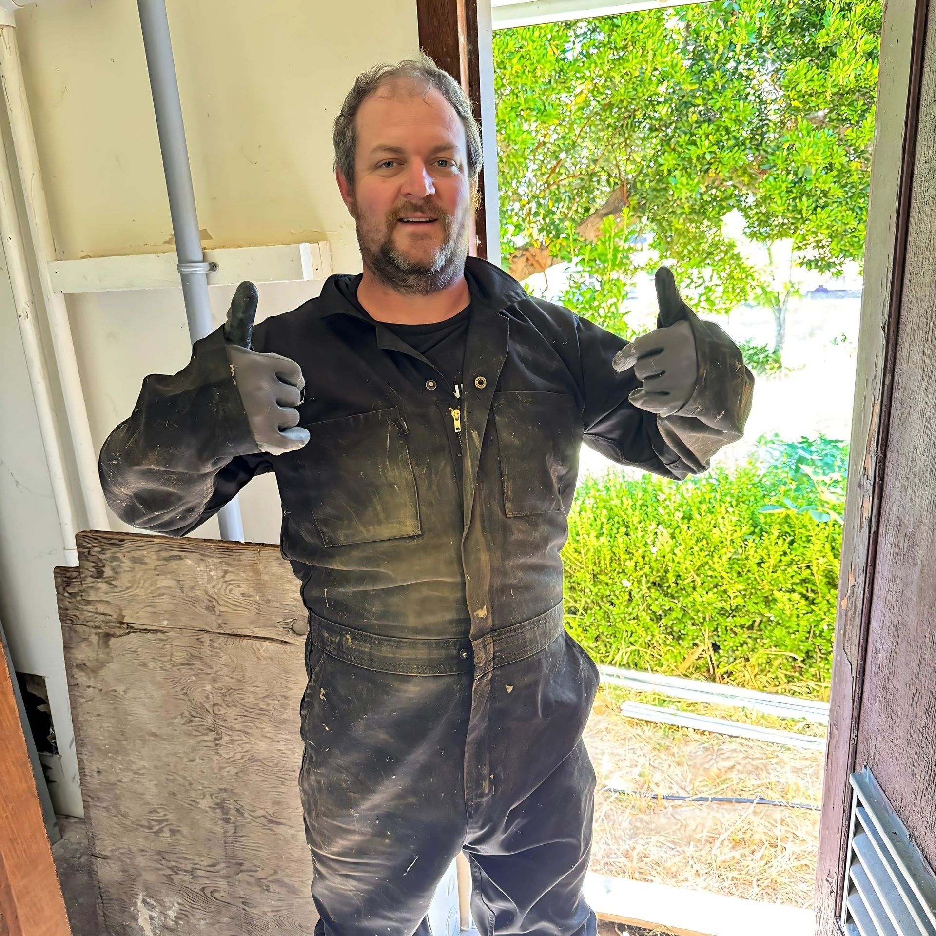 The Electric Pro - A man in a black jumpsuit is giving a thumbs up