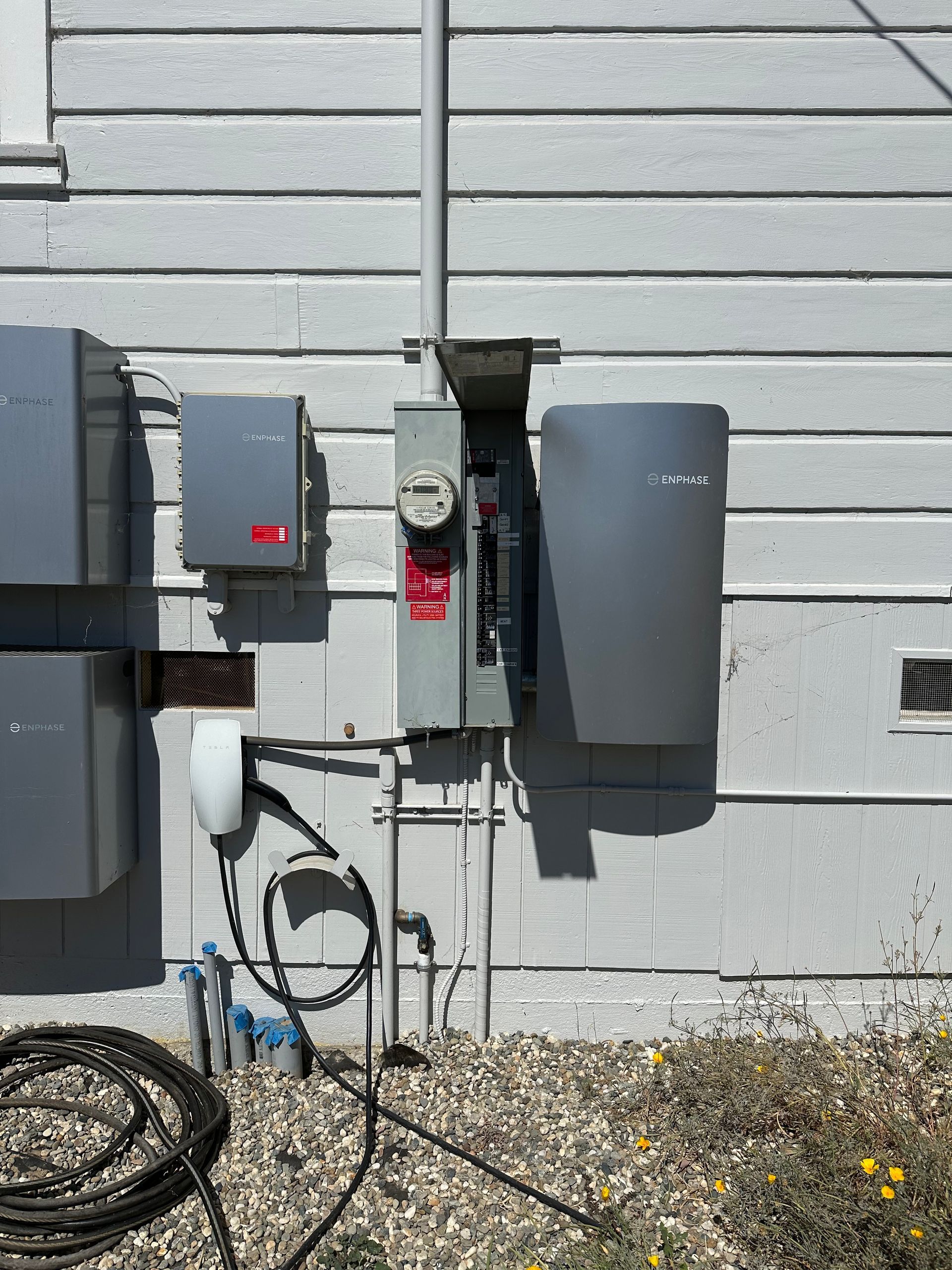 The Electric Pro - There are a lot of electrical boxes on the side of a house.