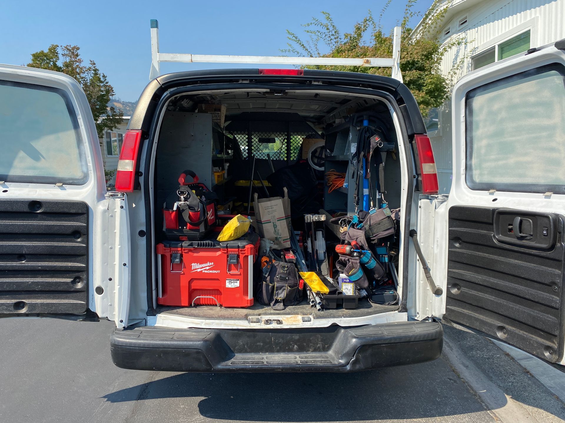 The Electric Pro - The back of a white van is filled with tools.