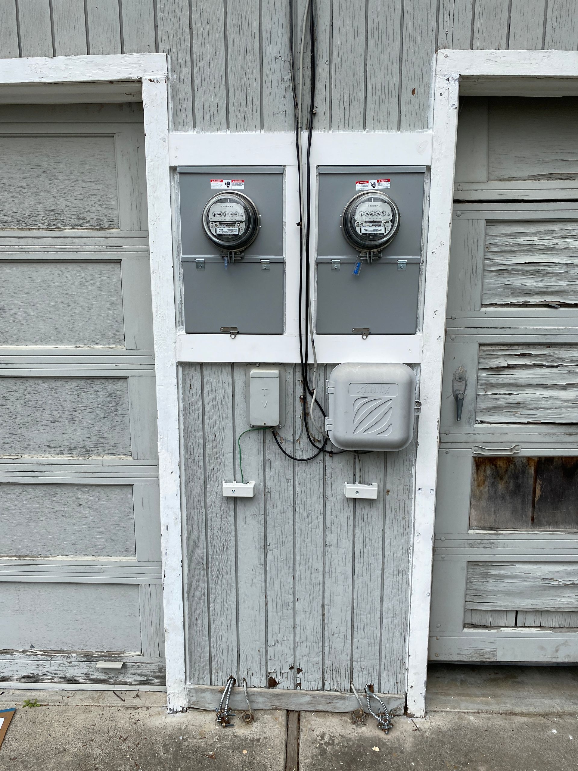 The Electric Pro - A garage door with two meter boxes attached to it.
