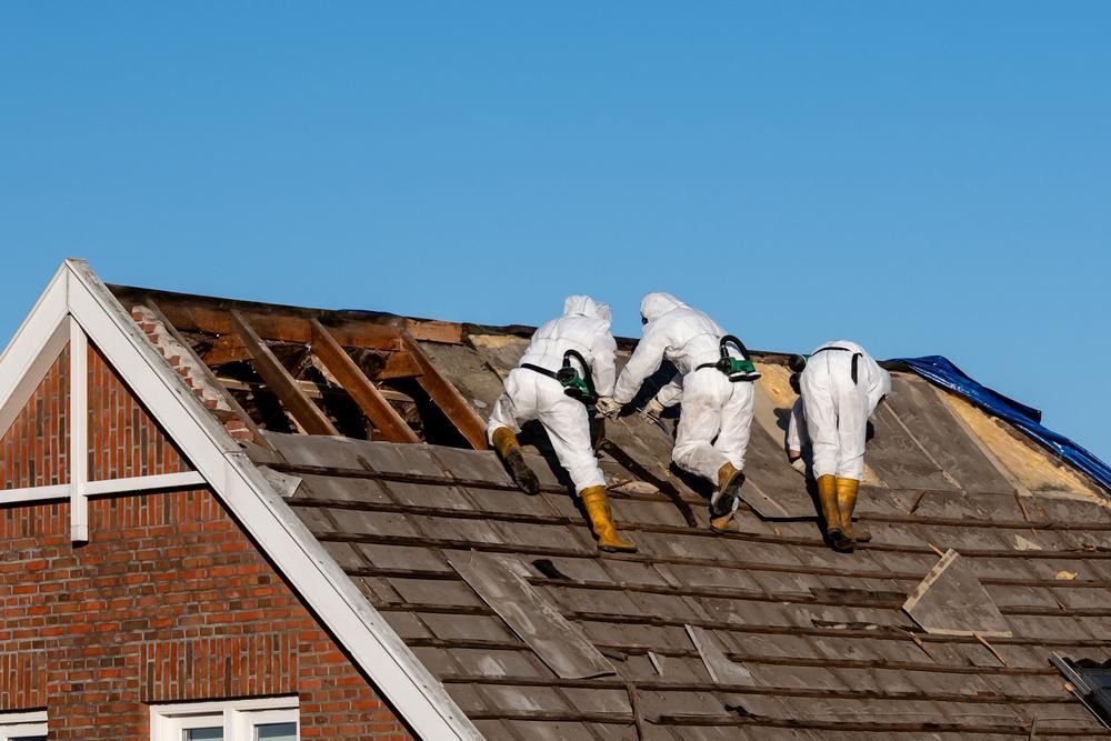 A Group Of People Are Working On The Roof Of A House — Roofworx Group In Bathurst, NSW