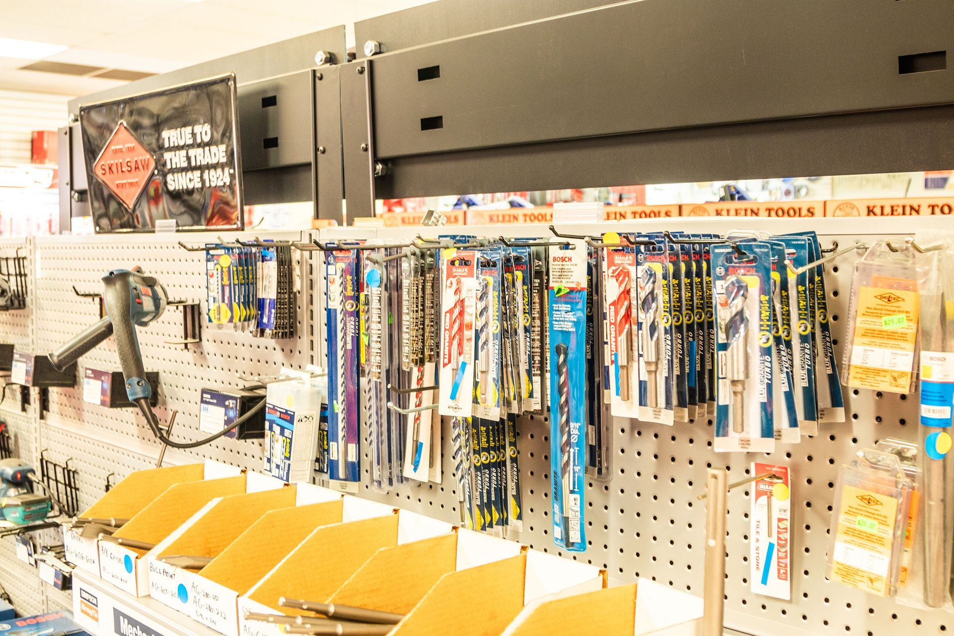 A bunch of tools are hanging on a wall in a store.