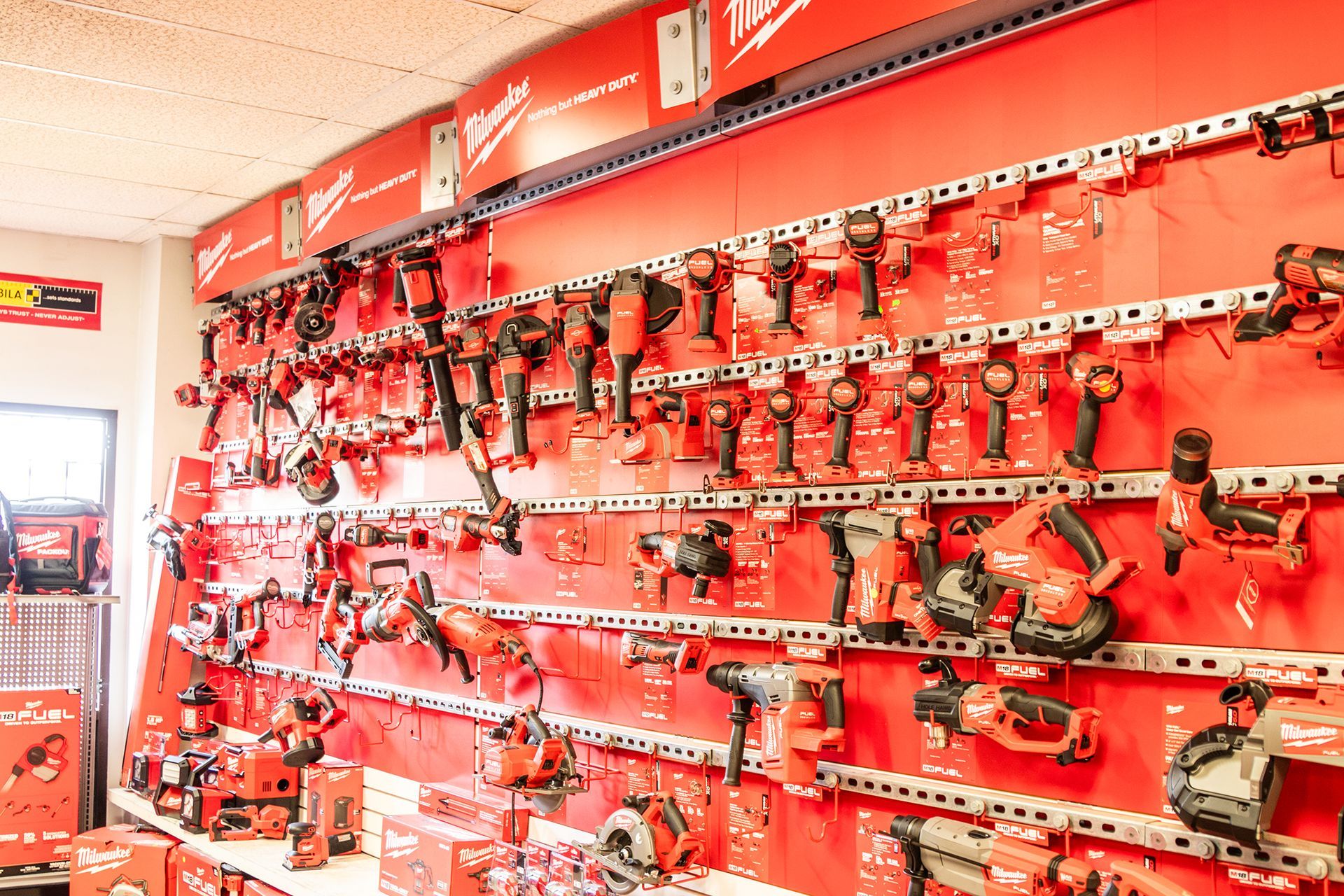 A wall filled with lots of red tools in a store.