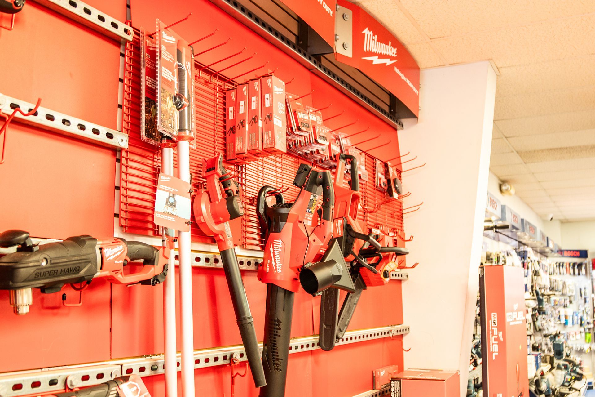 A bunch of tools are hanging on a wall in a store.