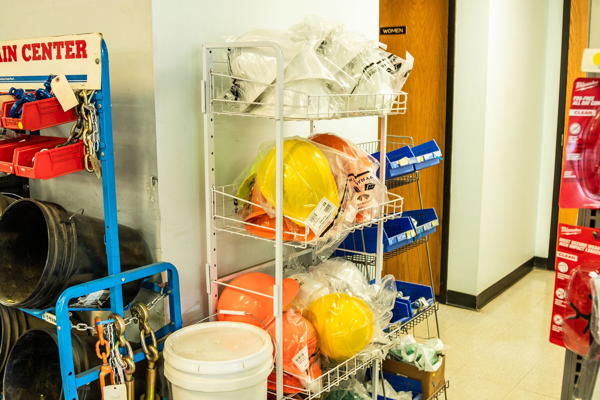 A shelf filled with hard hats and buckets in a room.