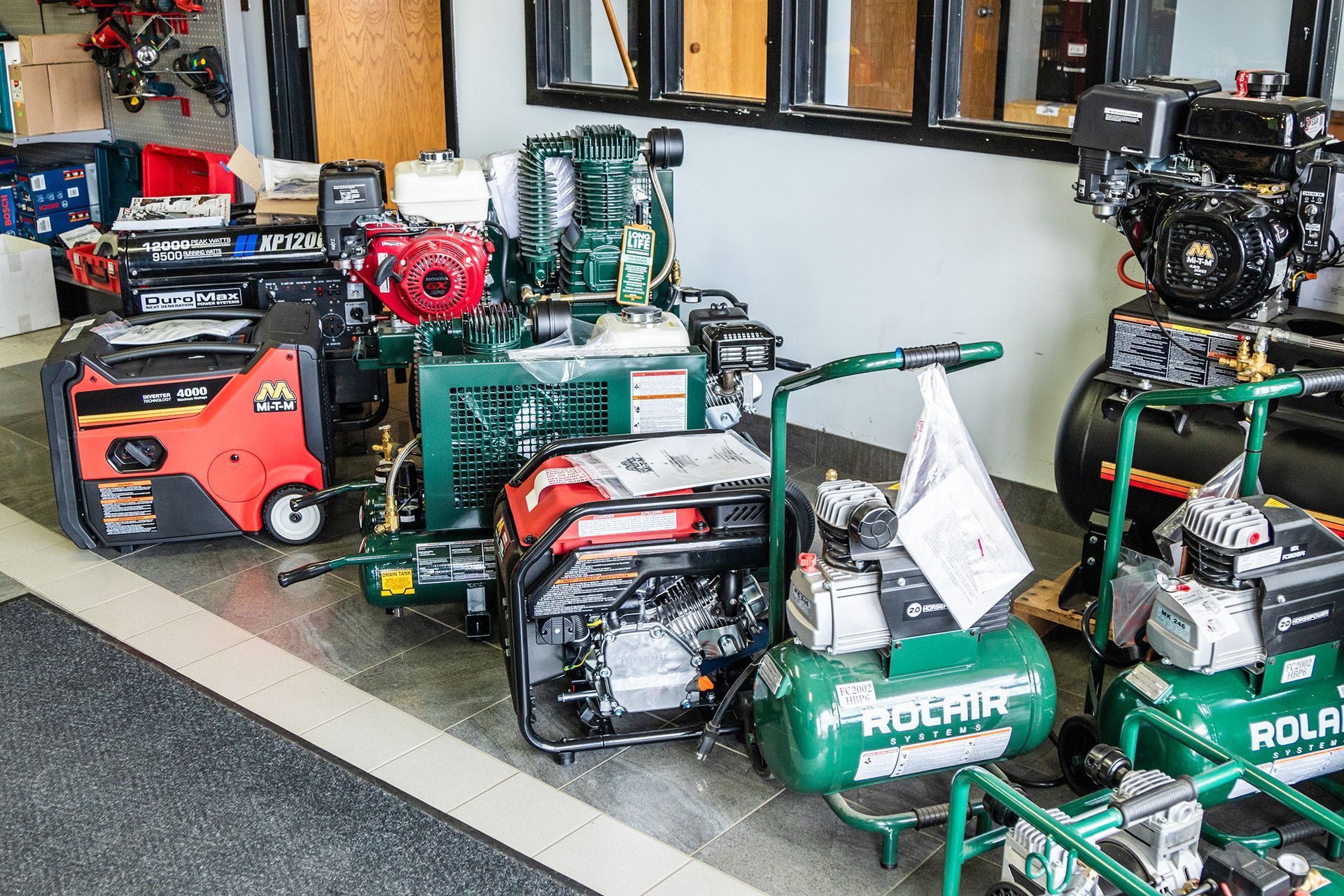 A row of air compressors are lined up in a room.