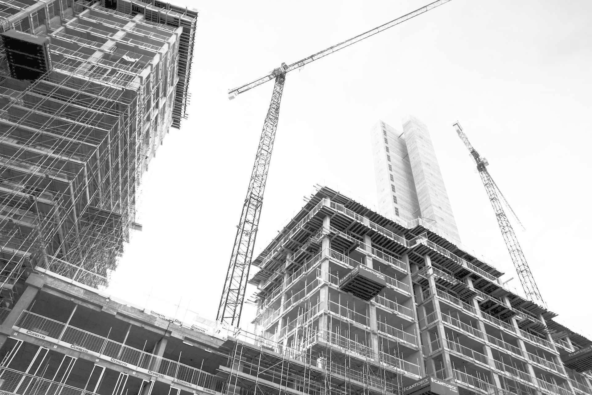 grayscale photo of crane in front of building