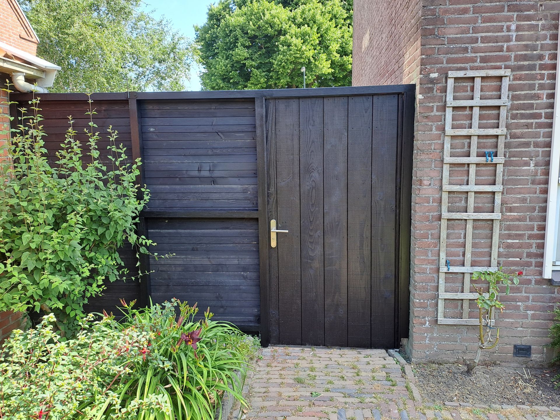 Een bakstenen gebouw met een houten hek en een deur