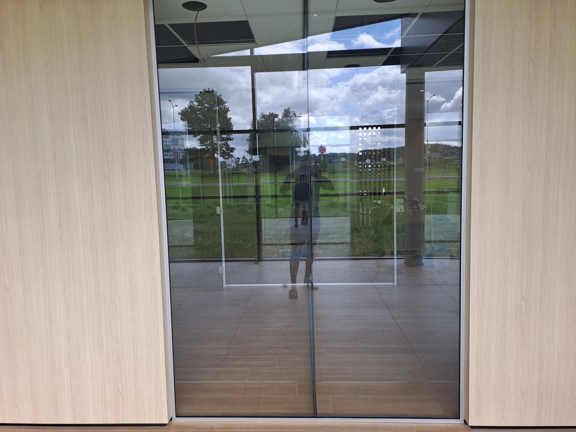 Een weerspiegeling van een persoon in een glazen deuropening