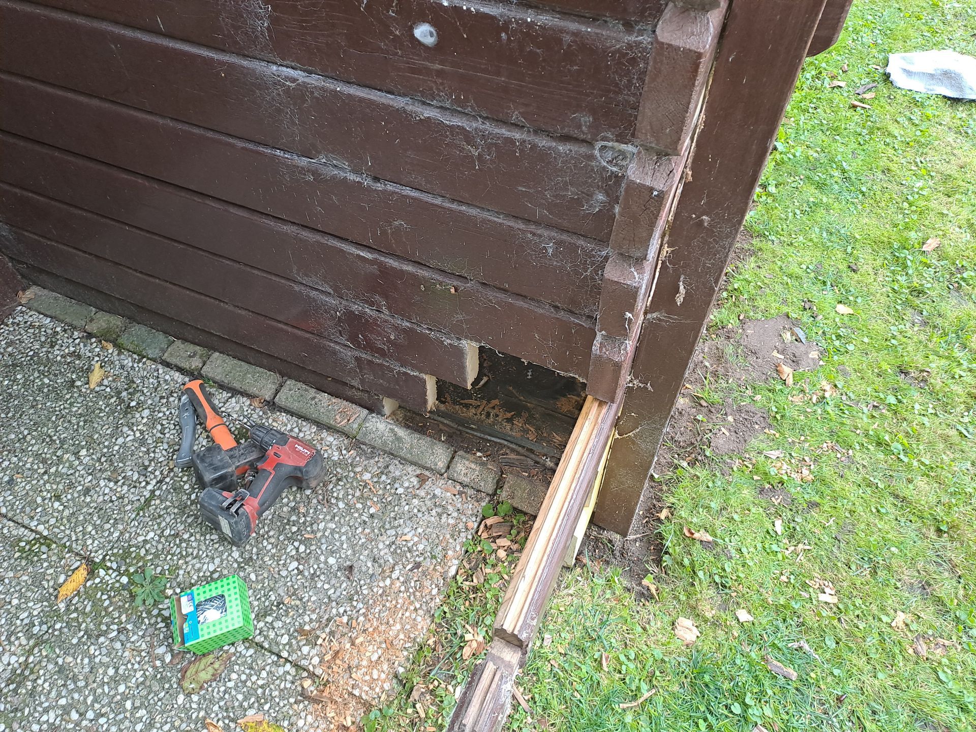 In het gras staat een houten schuurtje met een gat erin.