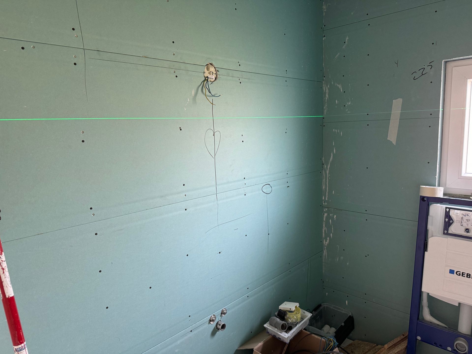 Een badkamer in aanbouw met een groene lijn op de muur
