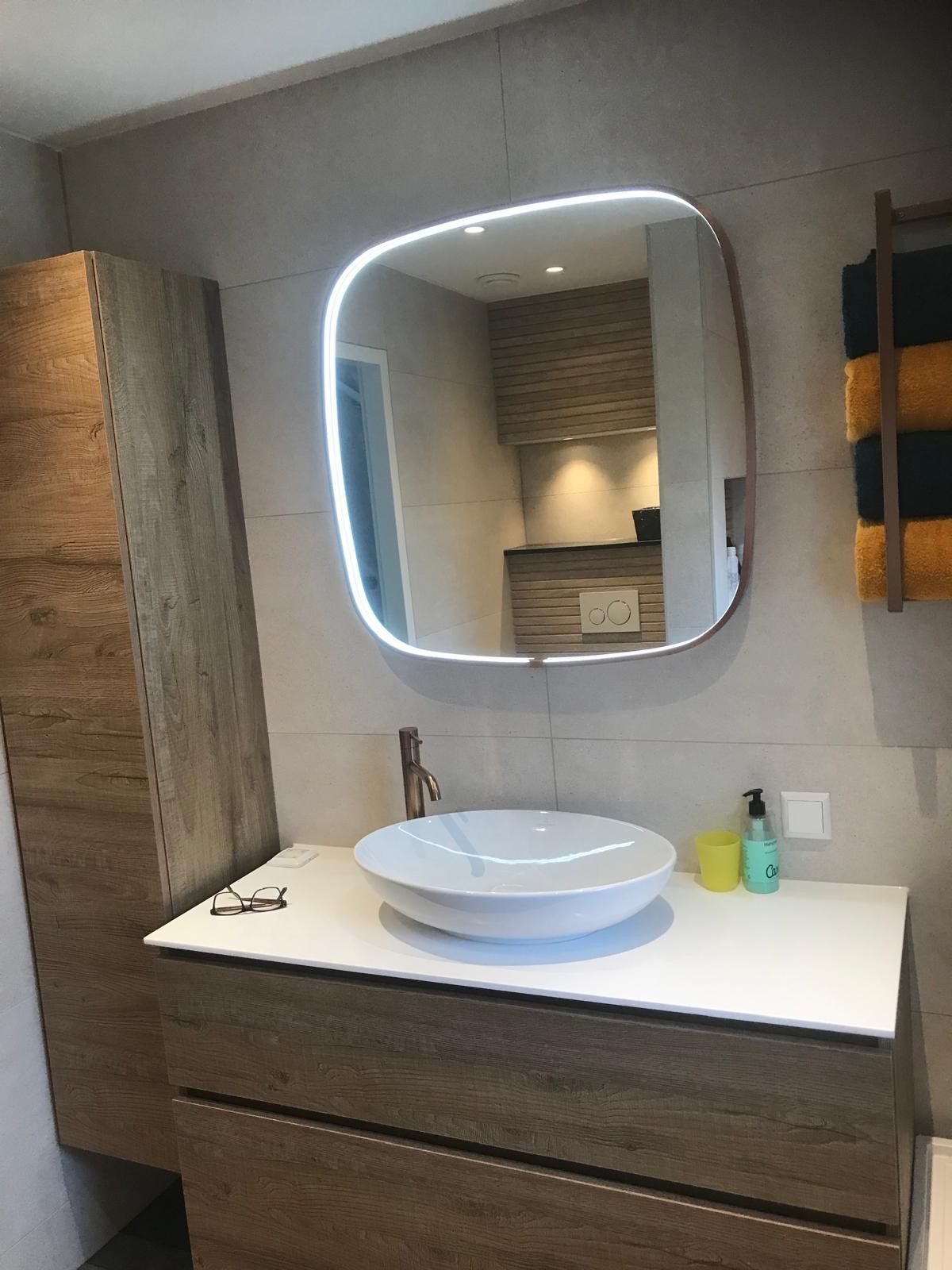 Een badkamer met een wastafel en een spiegel aan de muur.