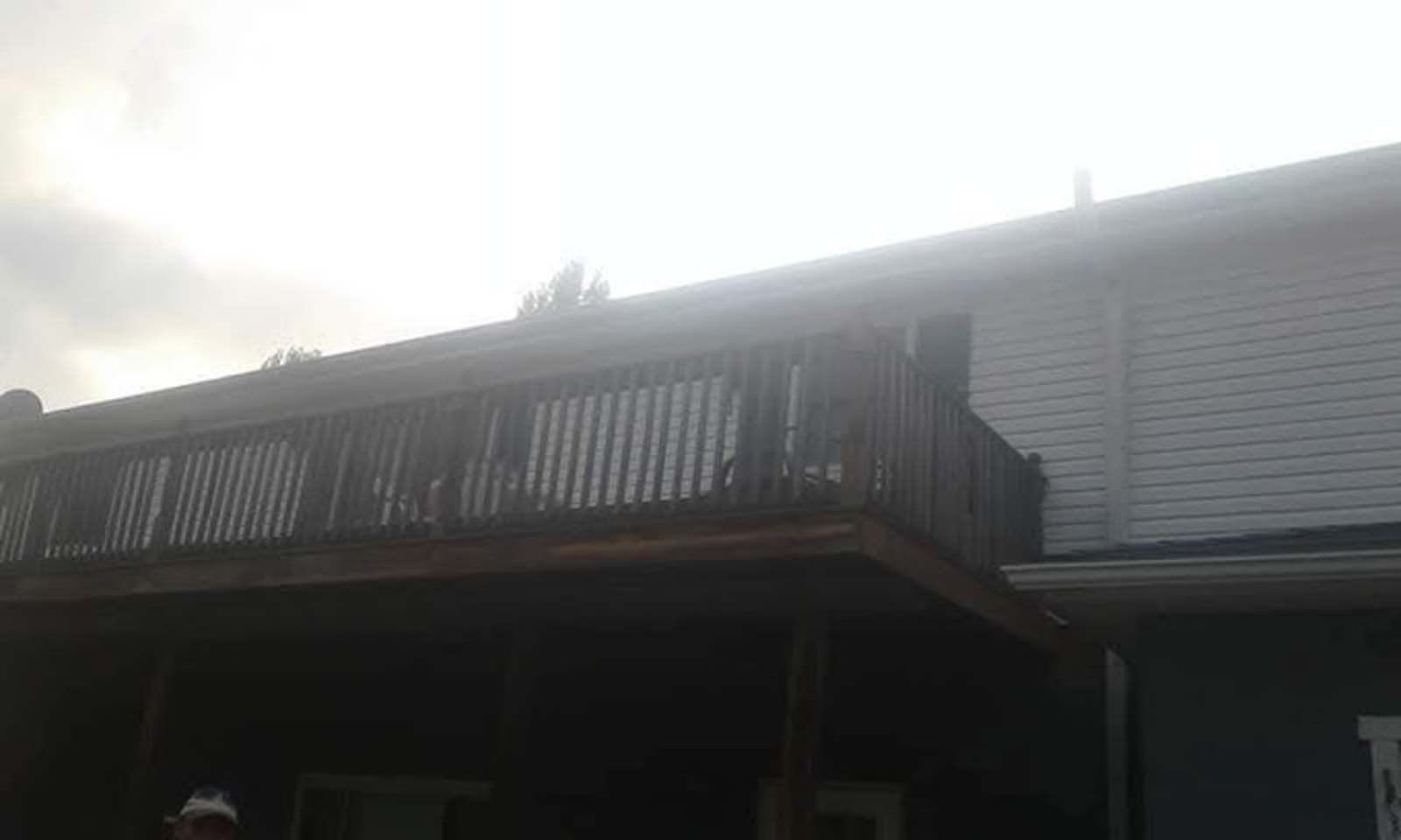 A large wooden deck on the side of a house.