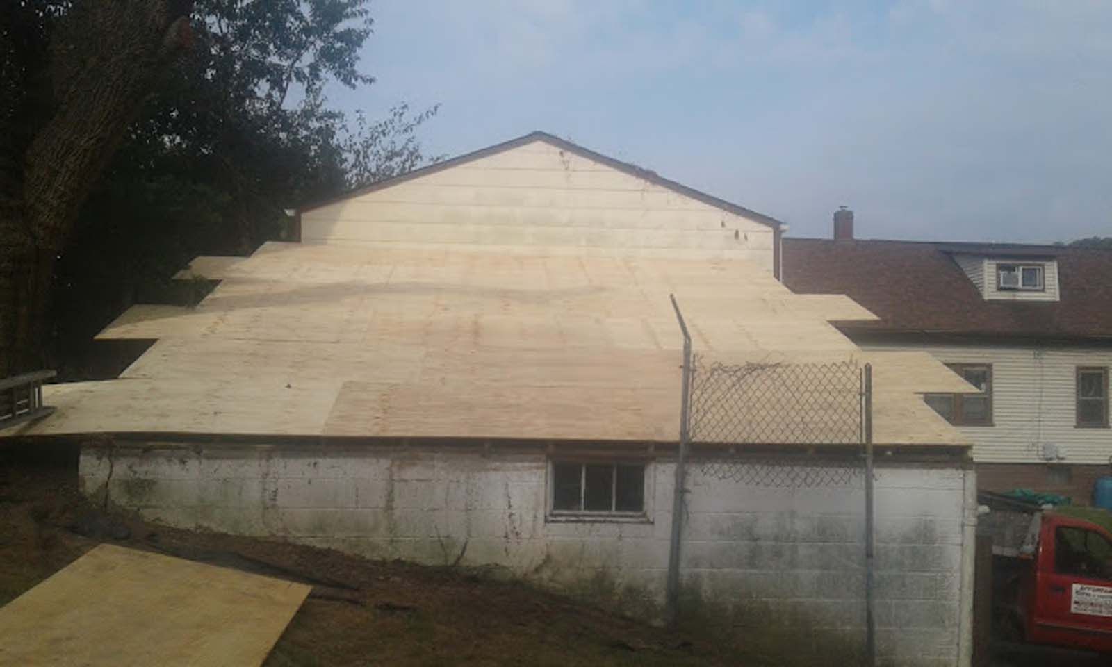 A house with a plywood roof is being built.
