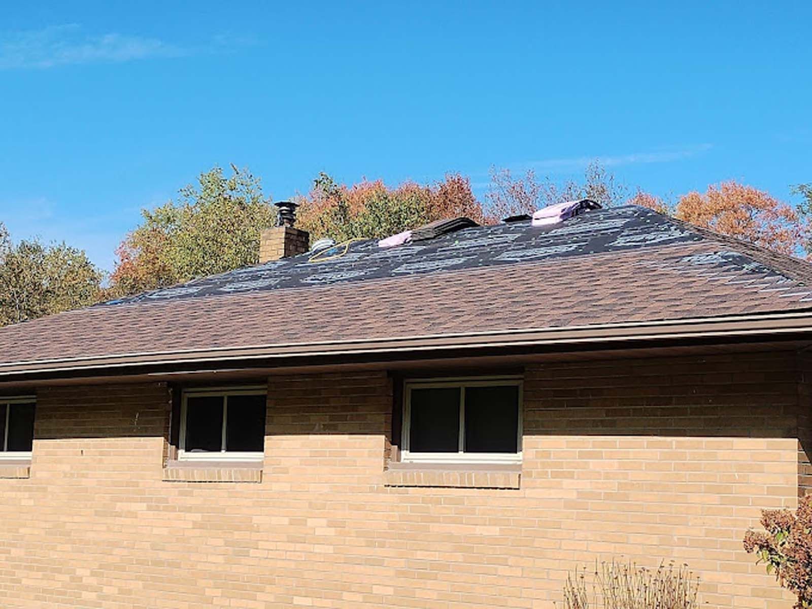 A brick house with a roof that is being installed.