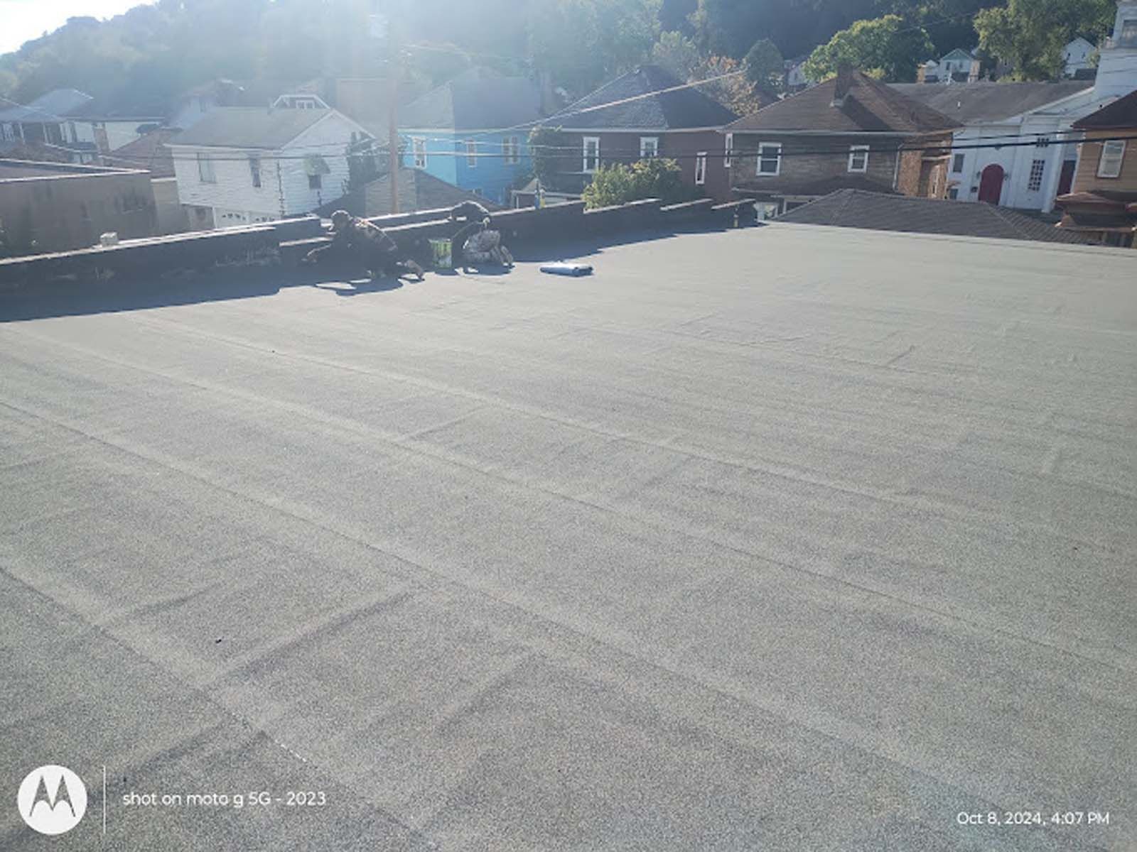 A roof with a few houses in the background and a motorola phone in the foreground.