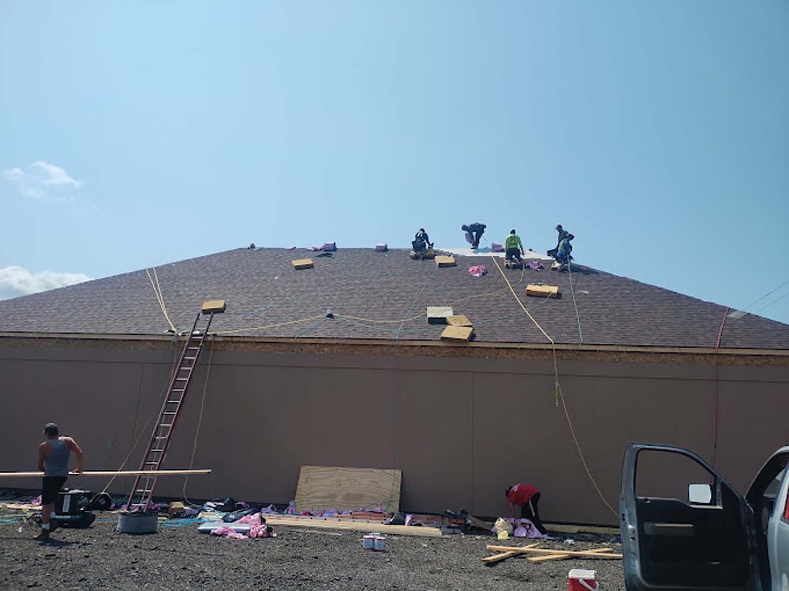 A group of people are working on the roof of a building.